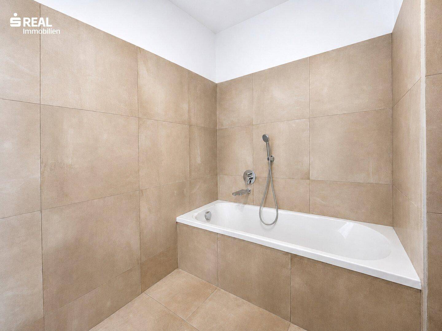 Modernes Badezimmer mit beigefarbenen Fliesen und einer integrierten Badewanne für entspannende Momente.