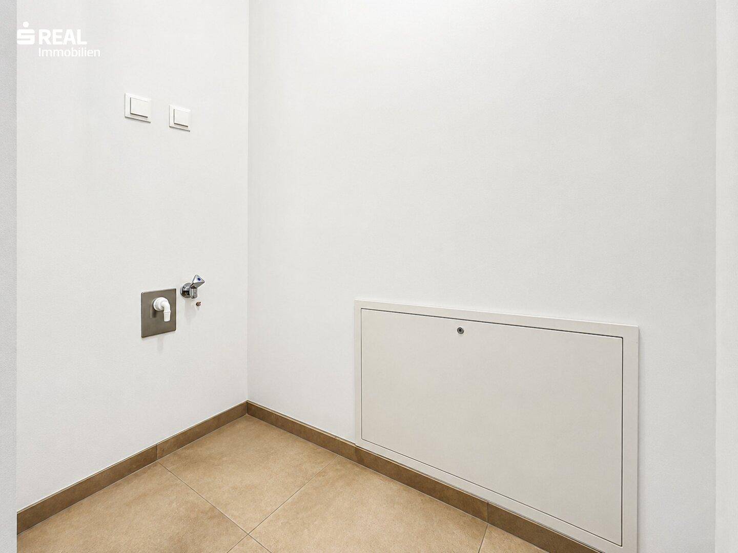 Praktischer Hauswirtschaftsraum mit Anschlüssen für Waschmaschine und Trockner sowie Fliesenboden.