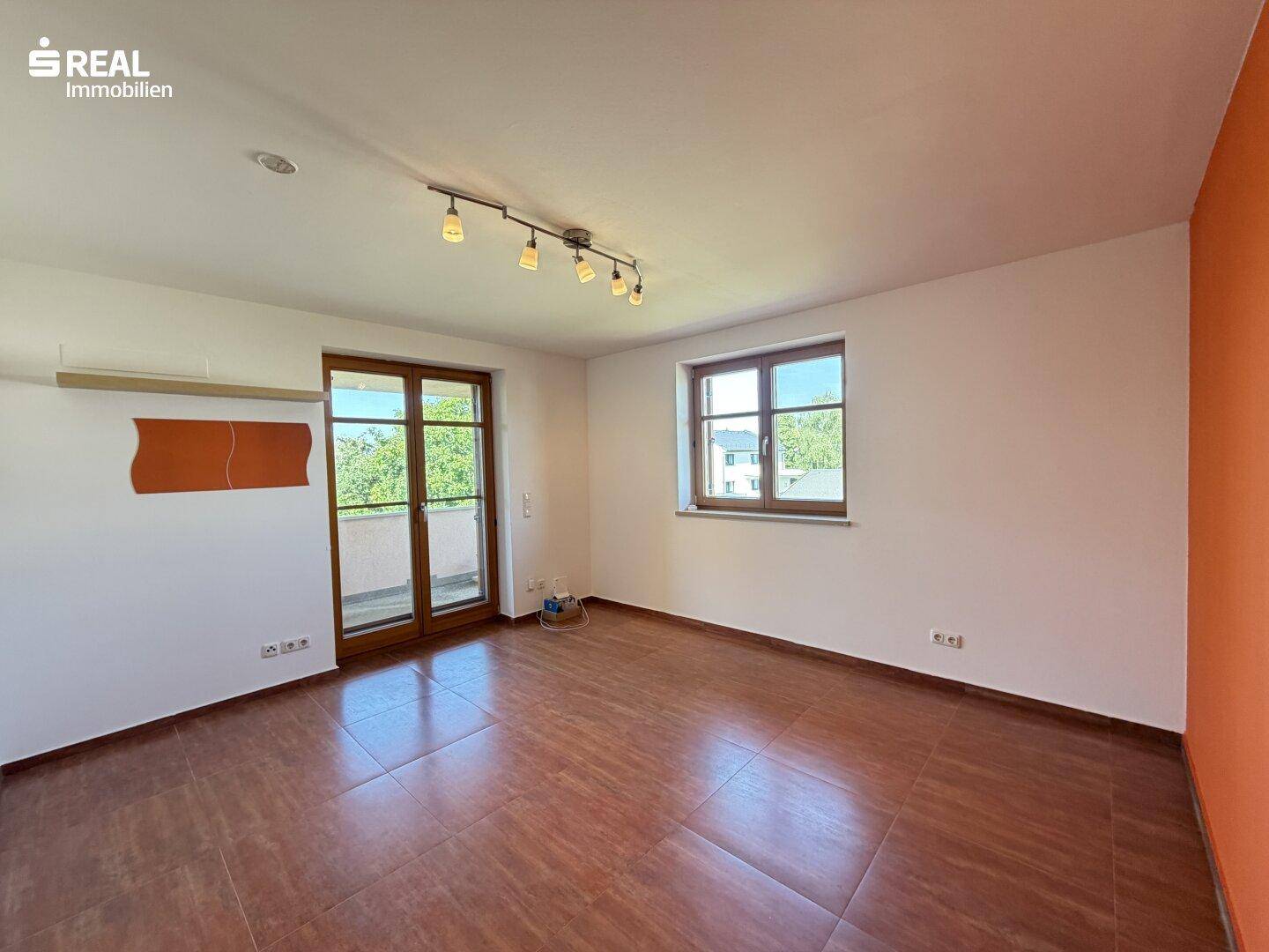 Geräumiges Schlafzimmer mit Zugang zum Balkon und großen Fenstern, die viel Licht spenden.