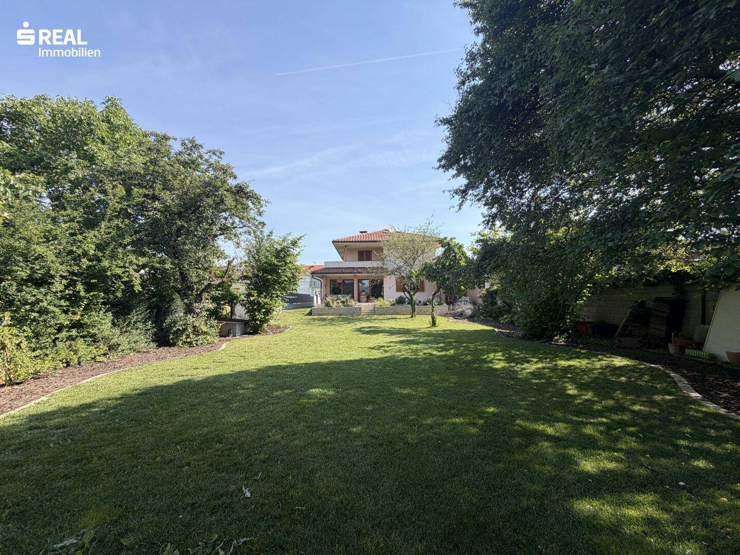 Großer, sonniger Garten mit altem Baumbestand und viel Platz für Erholung und Freizeitaktivitäten.