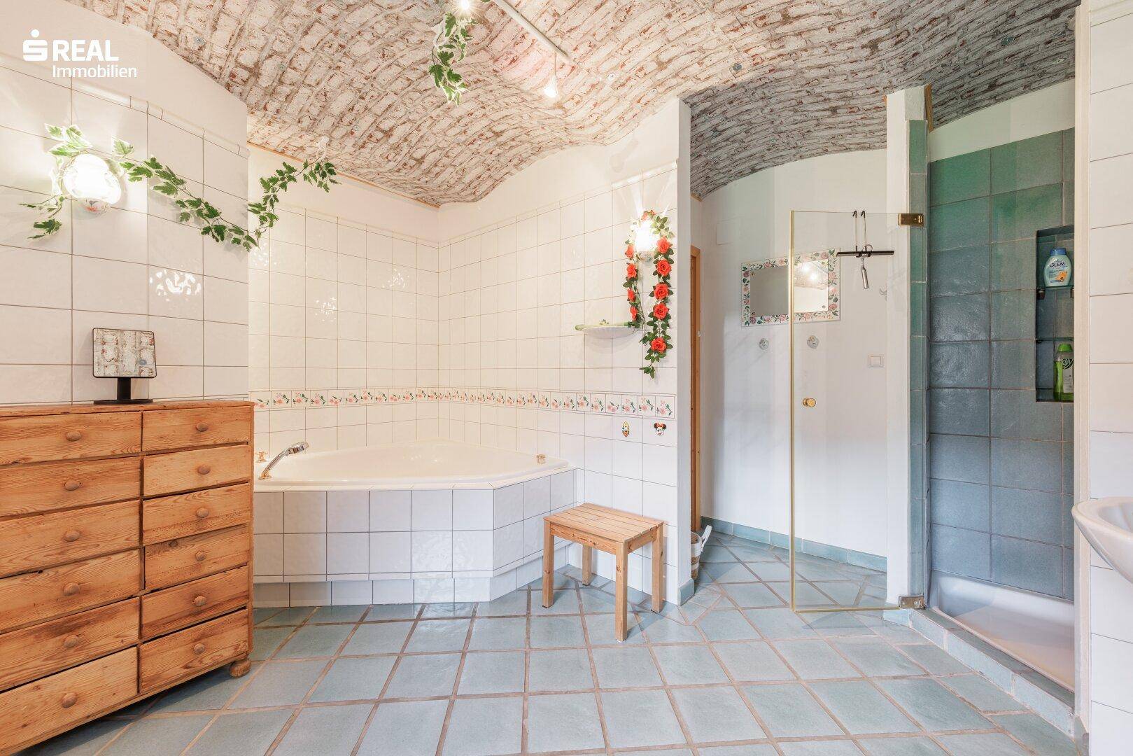 Geräumiges Badezimmer mit Eckbadewanne, separater Dusche und einzigartiger Gewölbedecke.