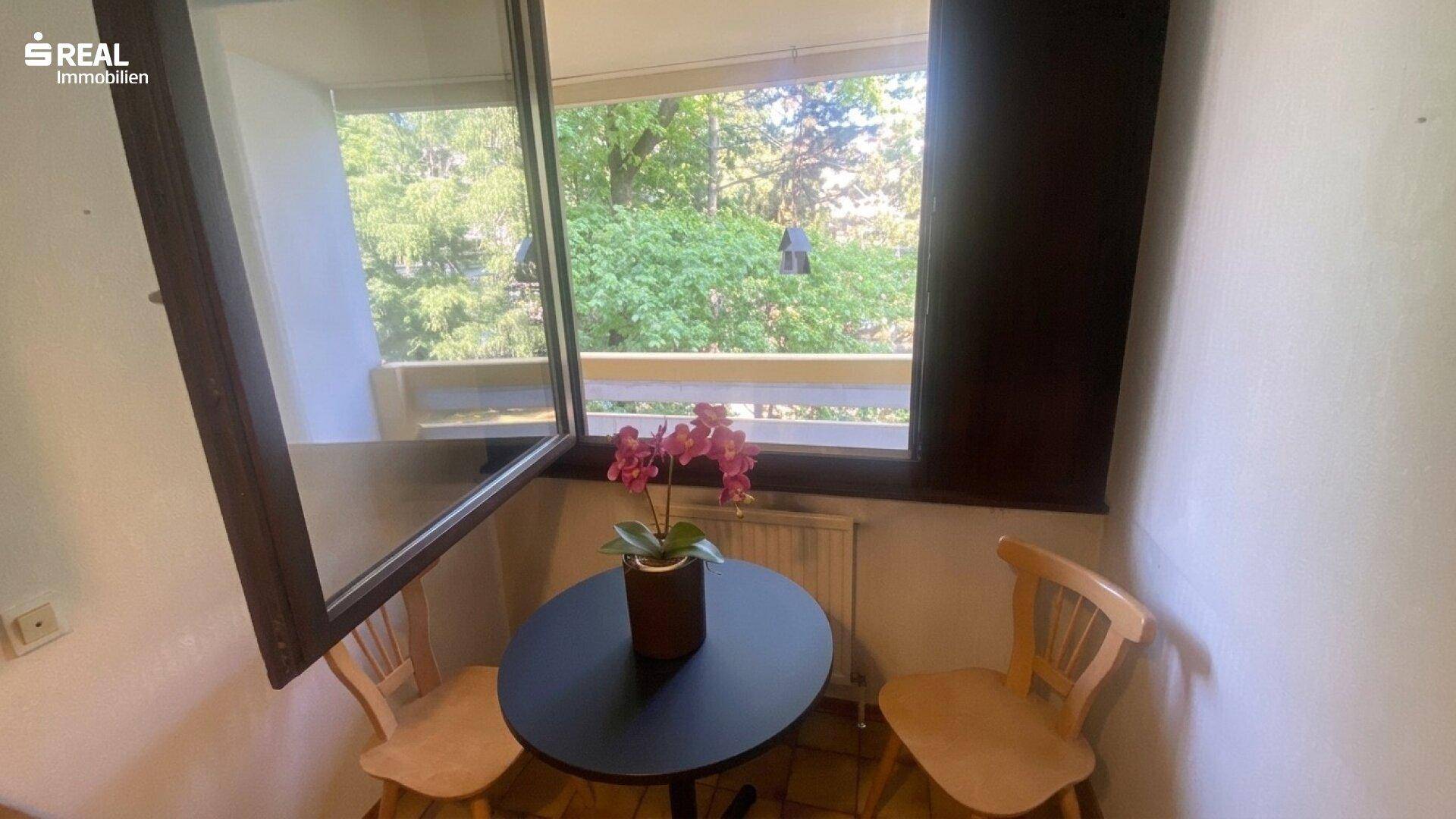 Kleiner Essbereich in der Küche mit Tisch und Stühlen am Fenster, das viel Licht bietet.