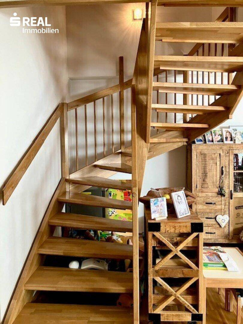 Robuste Holztreppe mit Geländer, die die verschiedenen Ebenen des Hauses verbindet.