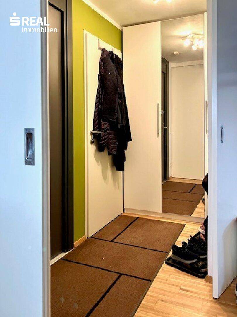 Heller Flur mit Spiegelschrank und Garderobe, bietet praktischen Stauraum.