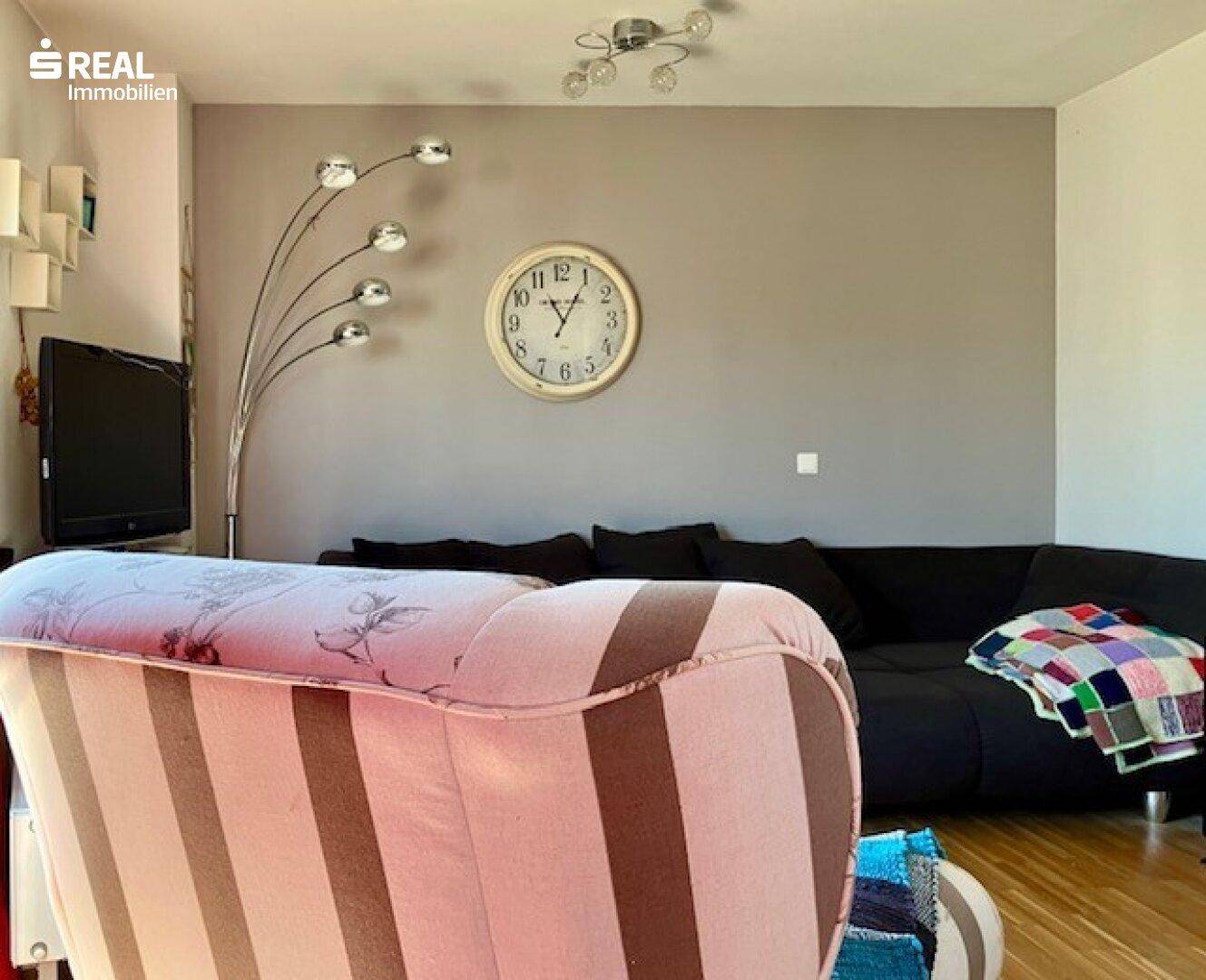 Gemütliche Wohnzimmerecke mit Sofa und Stehlampe, ideal zum Entspannen.