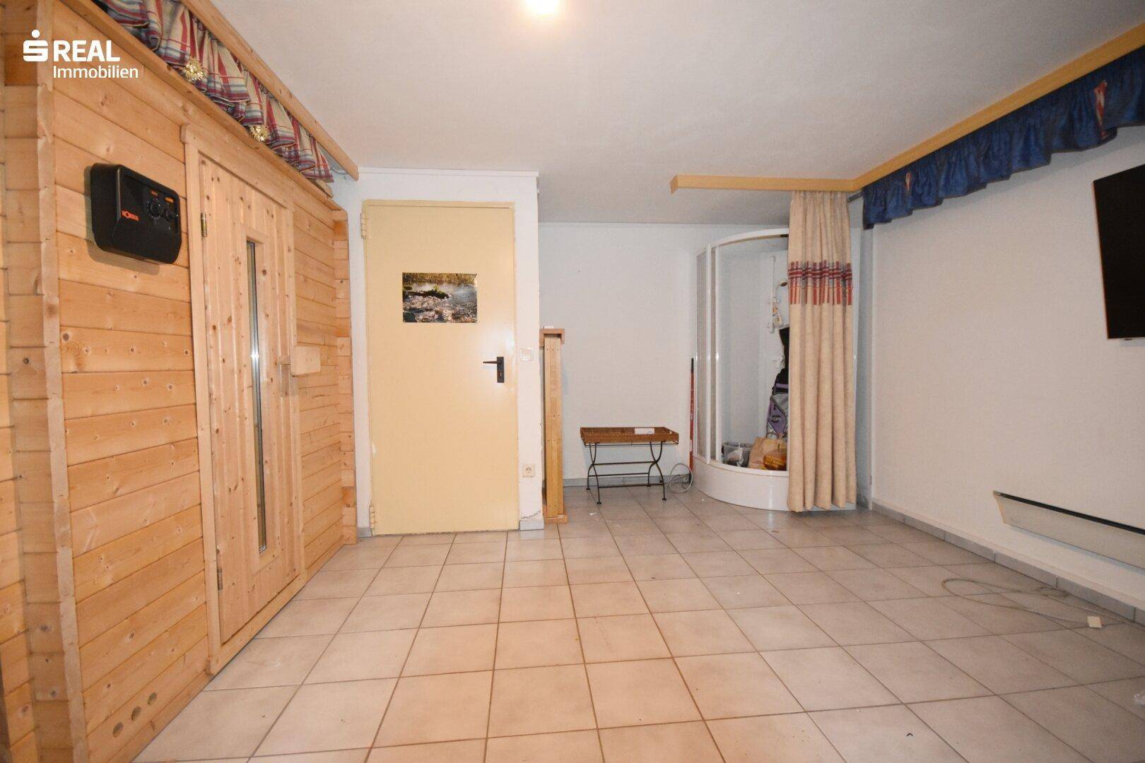 Kellerraum mit integrierter Sauna und Duschbereich für Wellnessmomente.