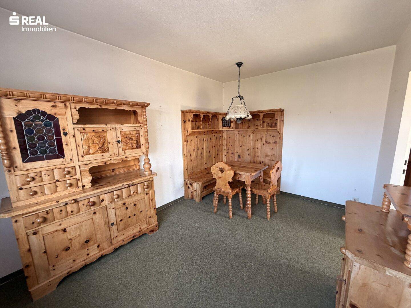 Rustikaler Essbereich mit traditionellen Holzmöbeln, Eckbank und einem großen Schrank.