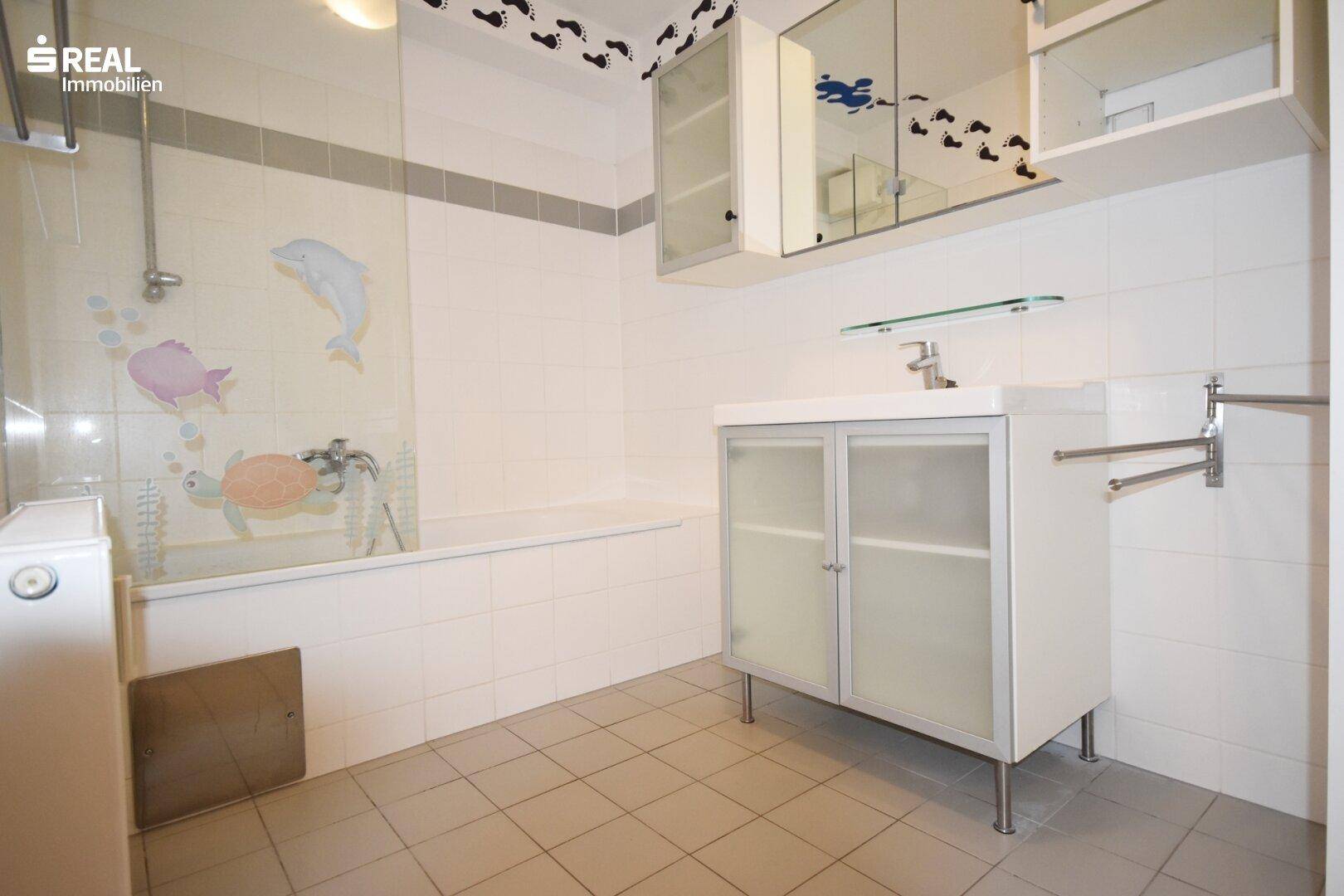 Badezimmer mit Badewanne, Waschbecken und Spiegelkabinett.