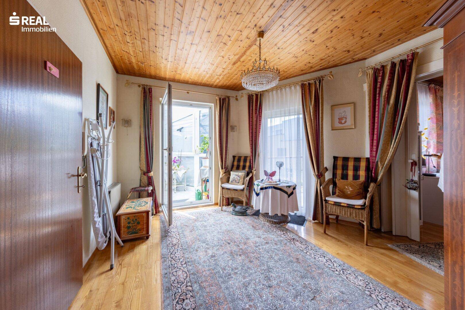 Zimmer mit Zugang zu einem kleinen Balkon, Holzdecke und traditioneller Einrichtung.