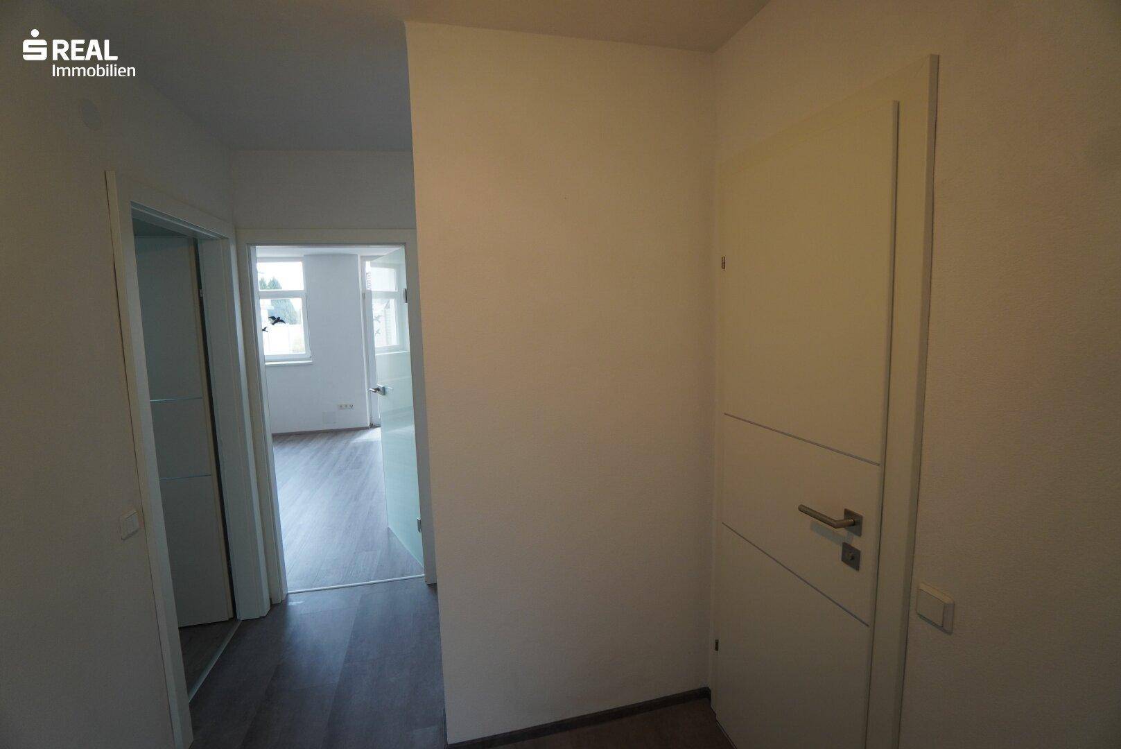 Flur mit Laminatboden und Zugang zu weiteren Räumen.