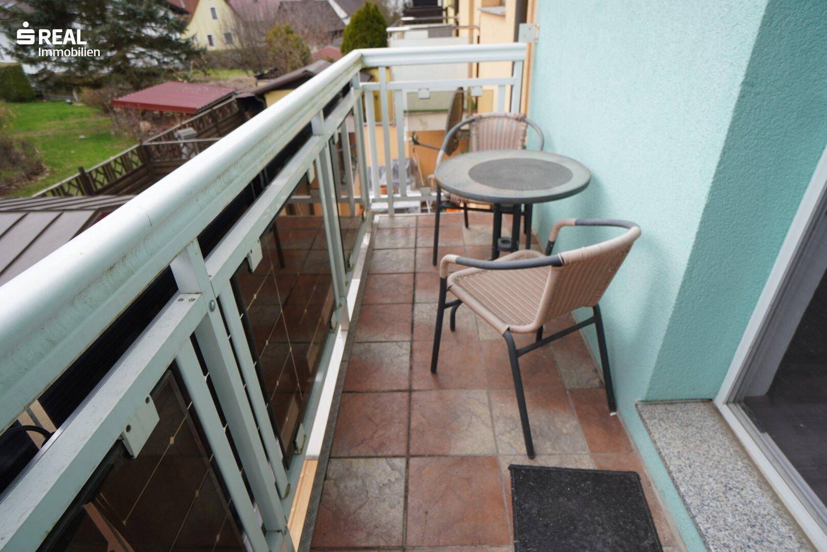 Gemütlicher Balkon mit Fliesenboden und Sitzgelegenheiten für entspannte Stunden im Freien.