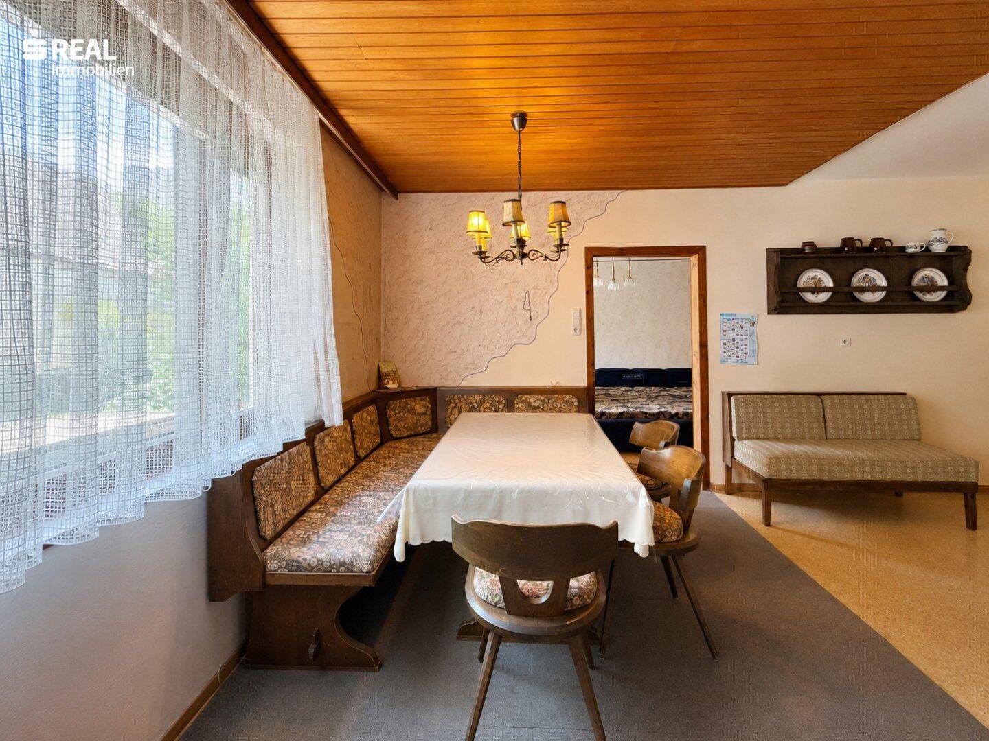 Rustikaler Essbereich mit Holztäfelung an der Decke und einer traditionellen Eckbank.