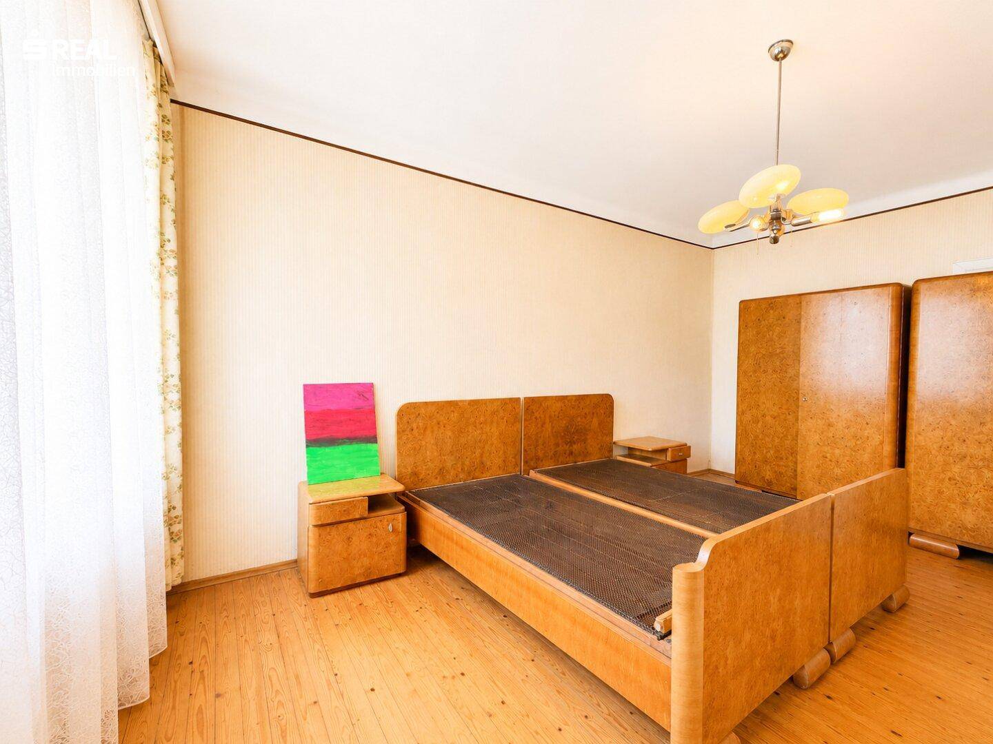 Geräumiges Schlafzimmer mit Holzbetten, passenden Schränken und hellem Holzfußboden.