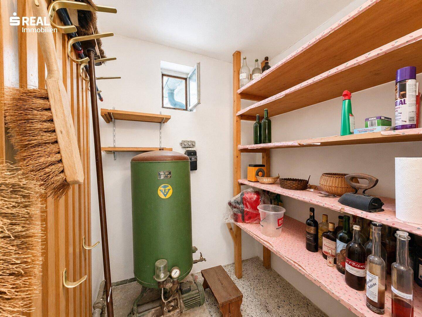 Abstellraum mit Regalen, Wasserboiler und kleinem Fenster für Belüftung.
