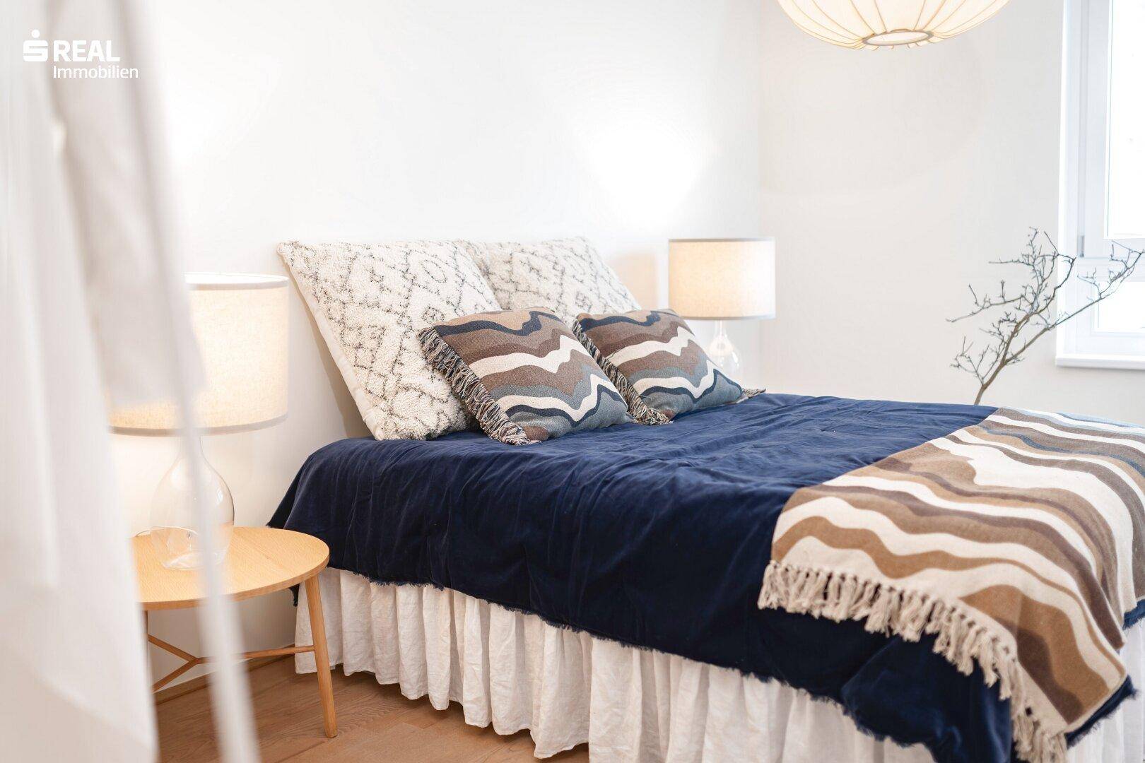 Nahaufnahme des Bettes im Schlafzimmer mit dekorativen Kissen und Decken.