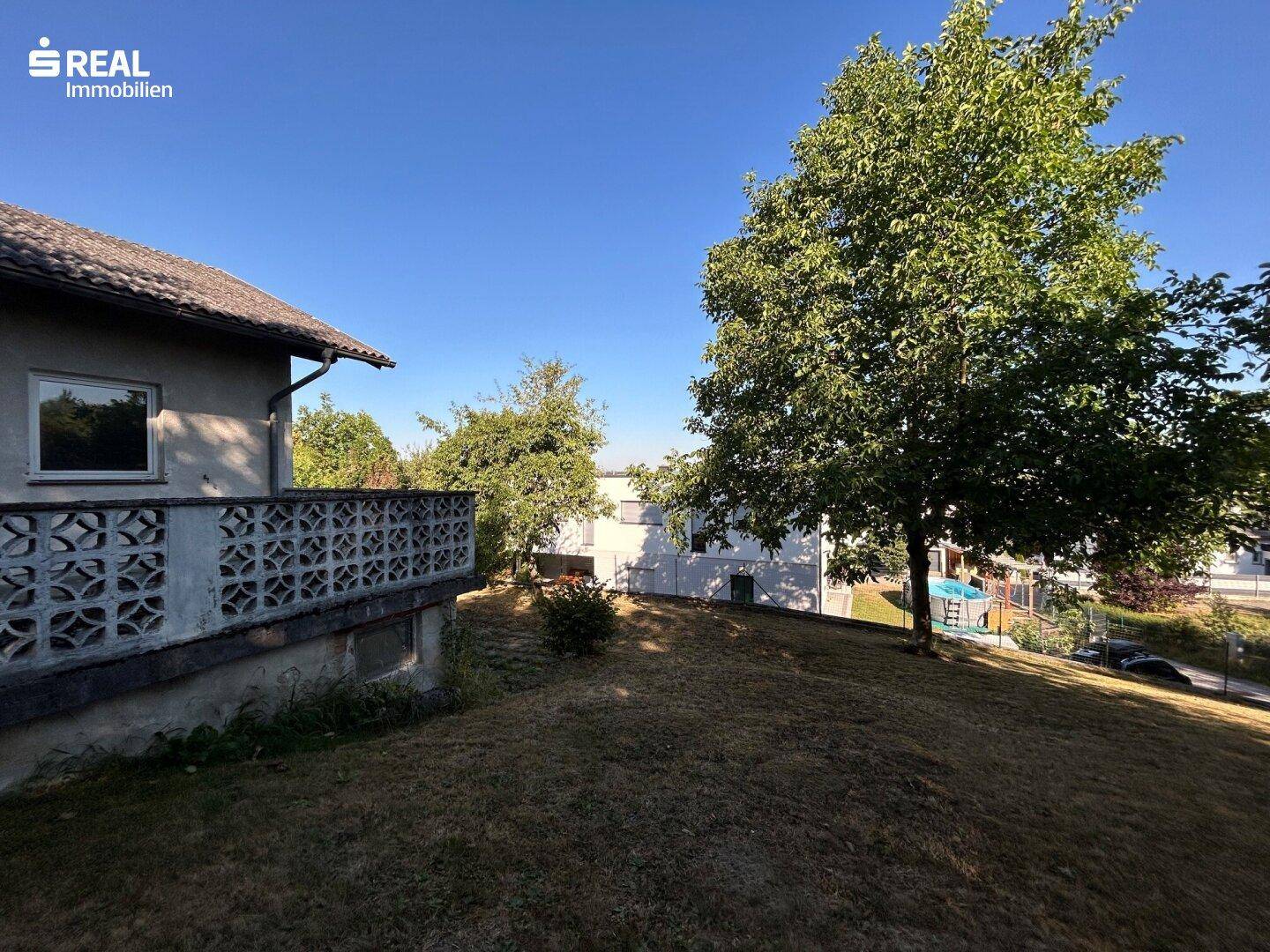 Großer Gartenbereich mit altem Baumbestand und Blick auf die Umgebung.