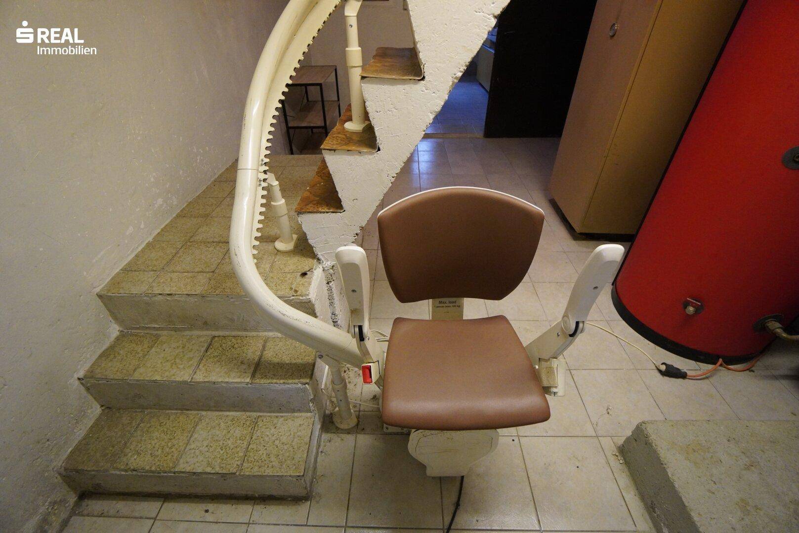 Treppenhaus im Keller mit einem installierten Treppenlift für barrierefreien Zugang zu den Etagen.