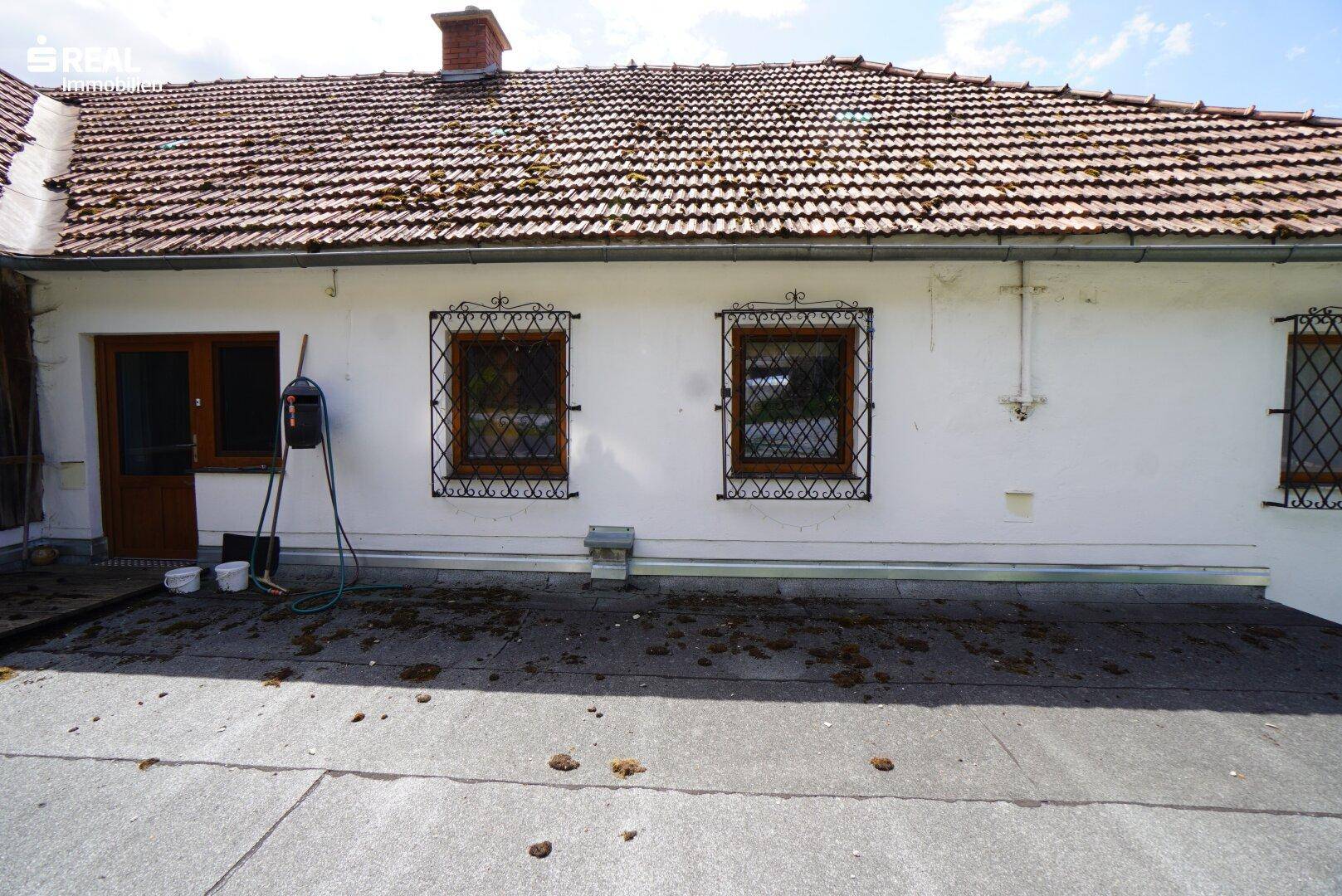 Außenansicht eines Gebäudes mit dekorativen Fenstergittern und Flachdachbereich.