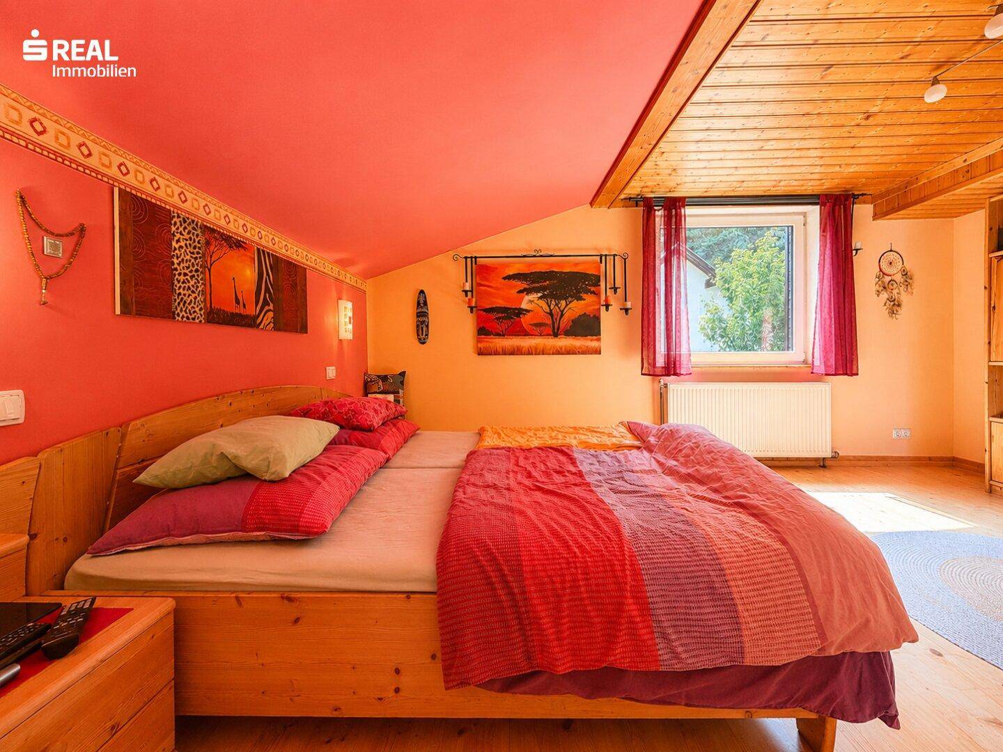 Detailansicht des Bettes im farbenfrohen Schlafzimmer mit afrikanisch inspirierten Dekorationen.