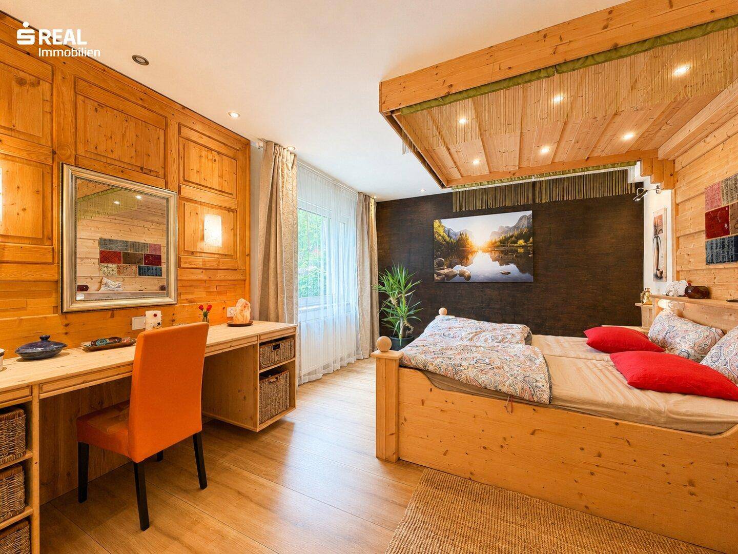 Schlafzimmer mit rustikalen Holzmöbeln, einem Schreibtisch und einem großen Wandbild.
