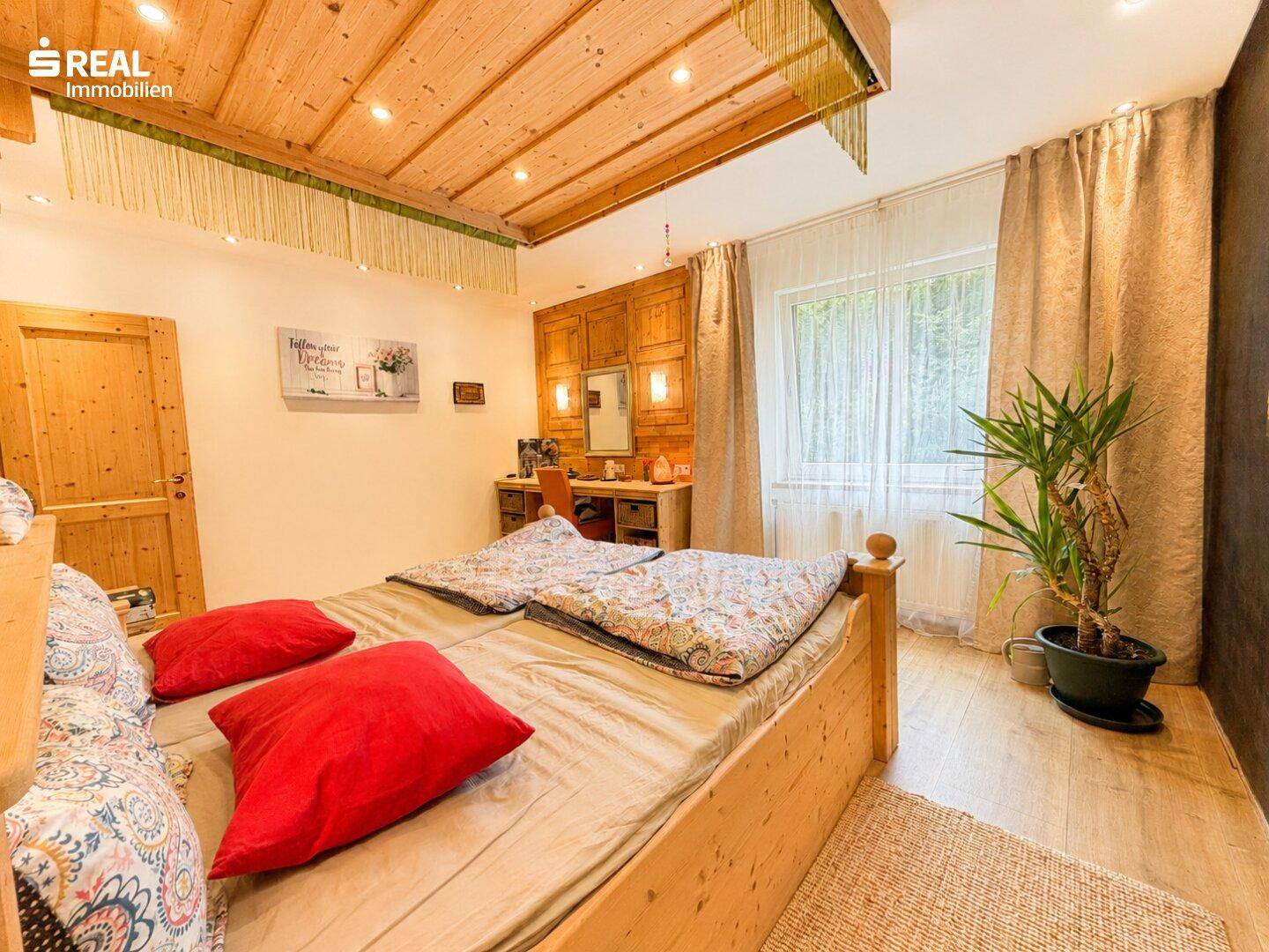 Helles Schlafzimmer mit zwei Einzelbetten, Holzdecke und einer Holztür.