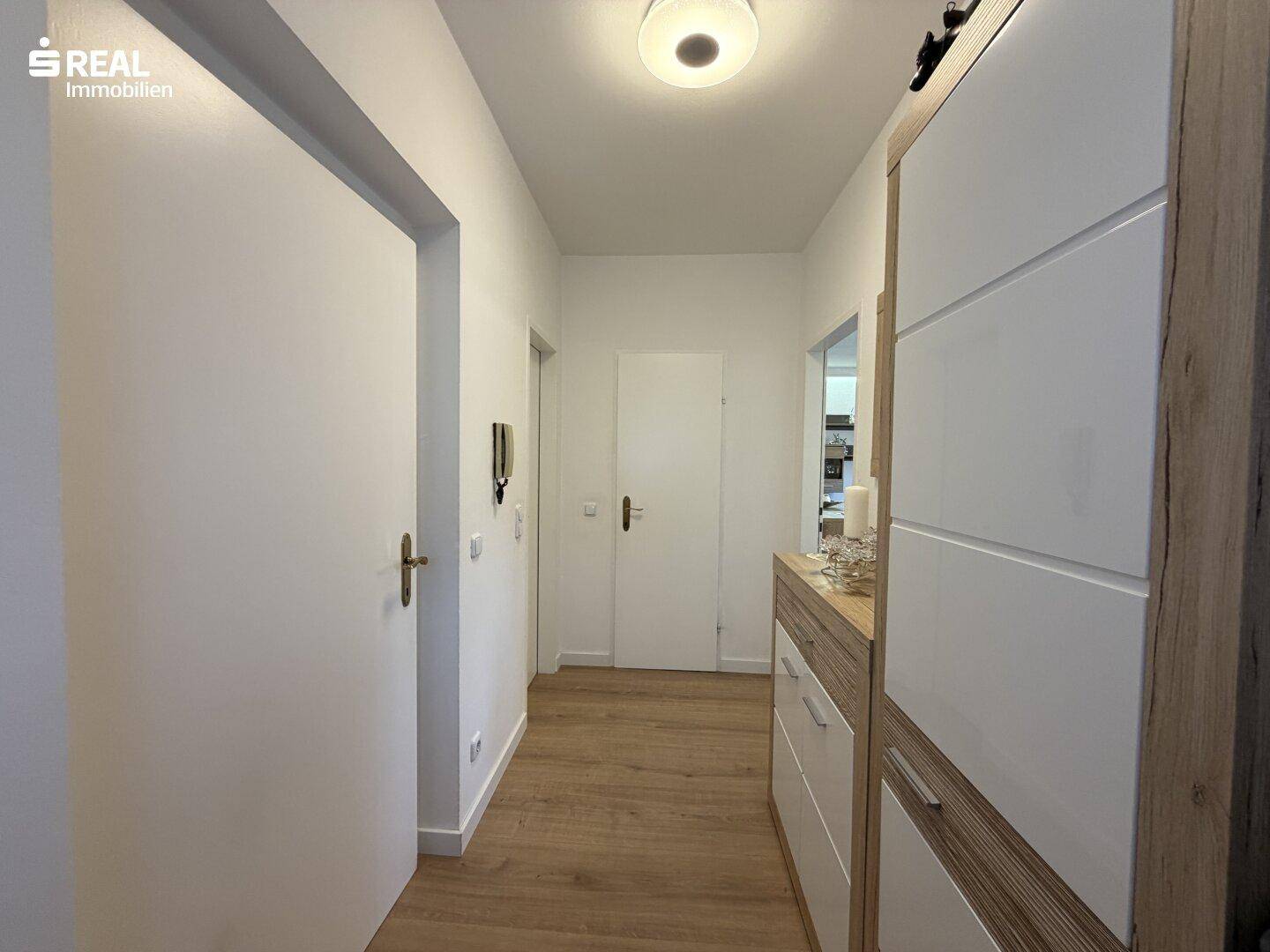 Heller Flur mit Laminatboden und modernem Schuhschrank.