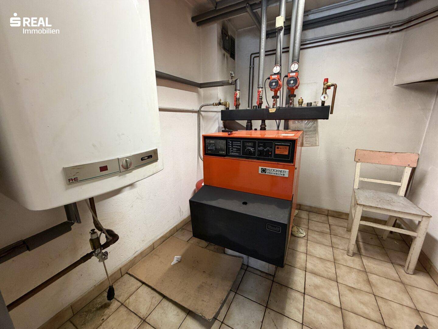 Heizungsraum mit Boiler, Heizungsanlage und gefliestem Boden.