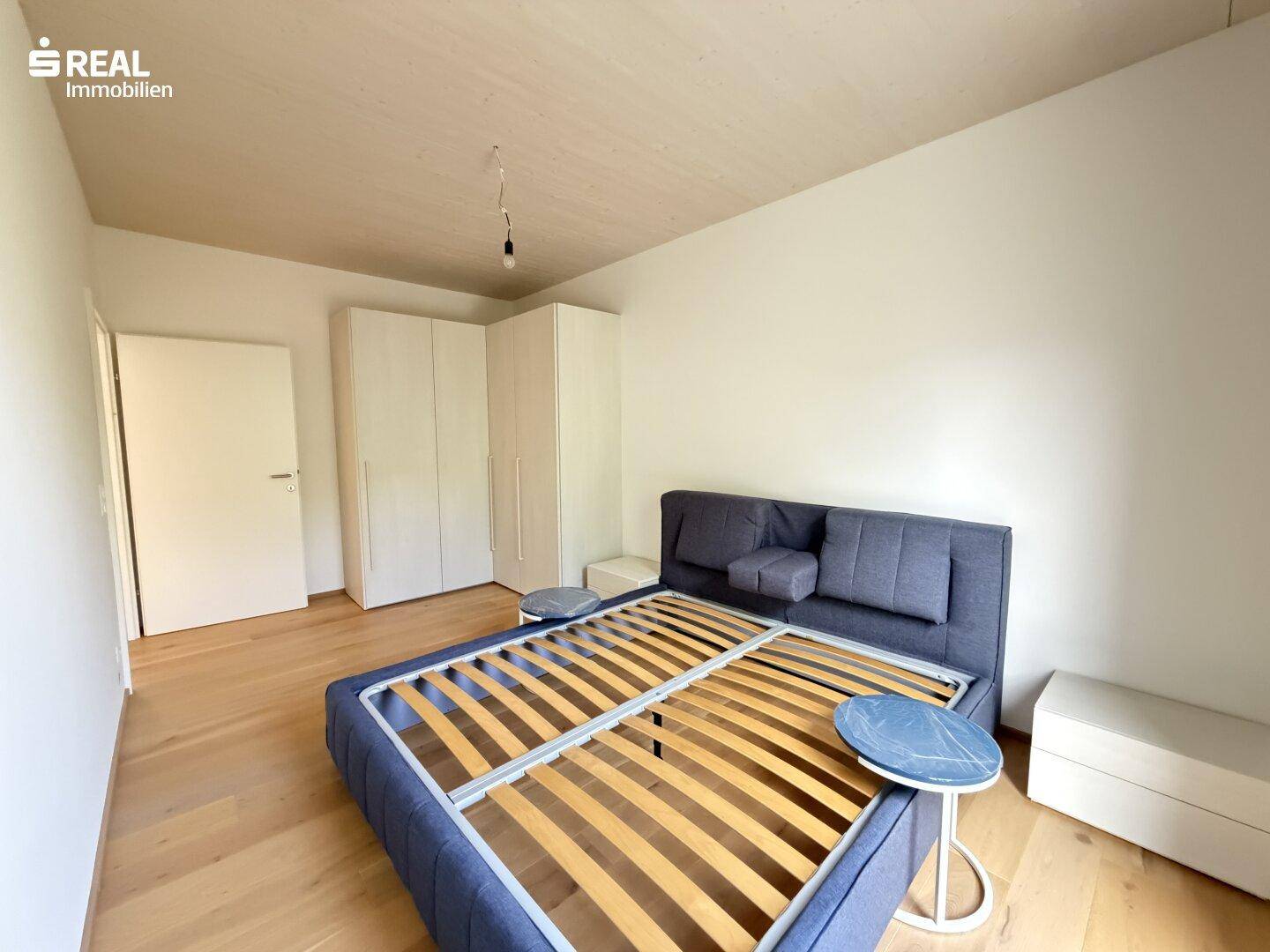 Geräumiges Schlafzimmer mit Holzboden und weißem Einbauschrank, bereit zur individuellen Gestaltung.