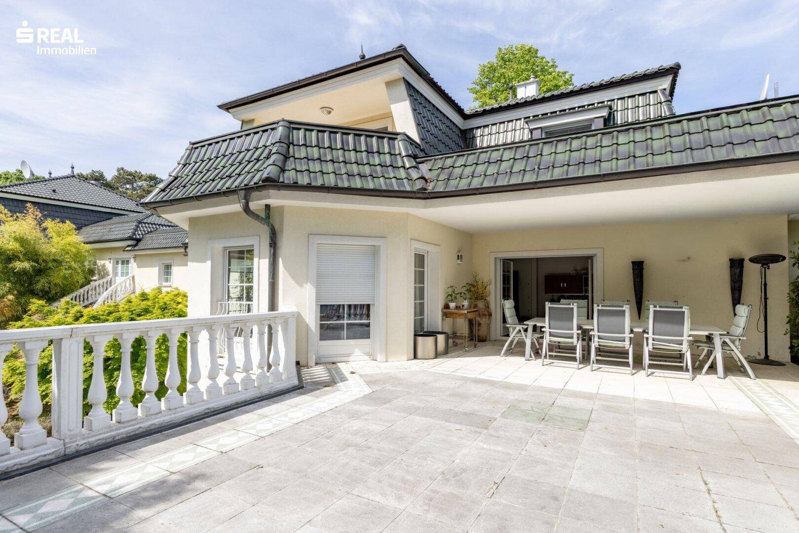 Große gepflasterte Terrasse mit klassischer Balustrade und viel Platz zum Entspannen.