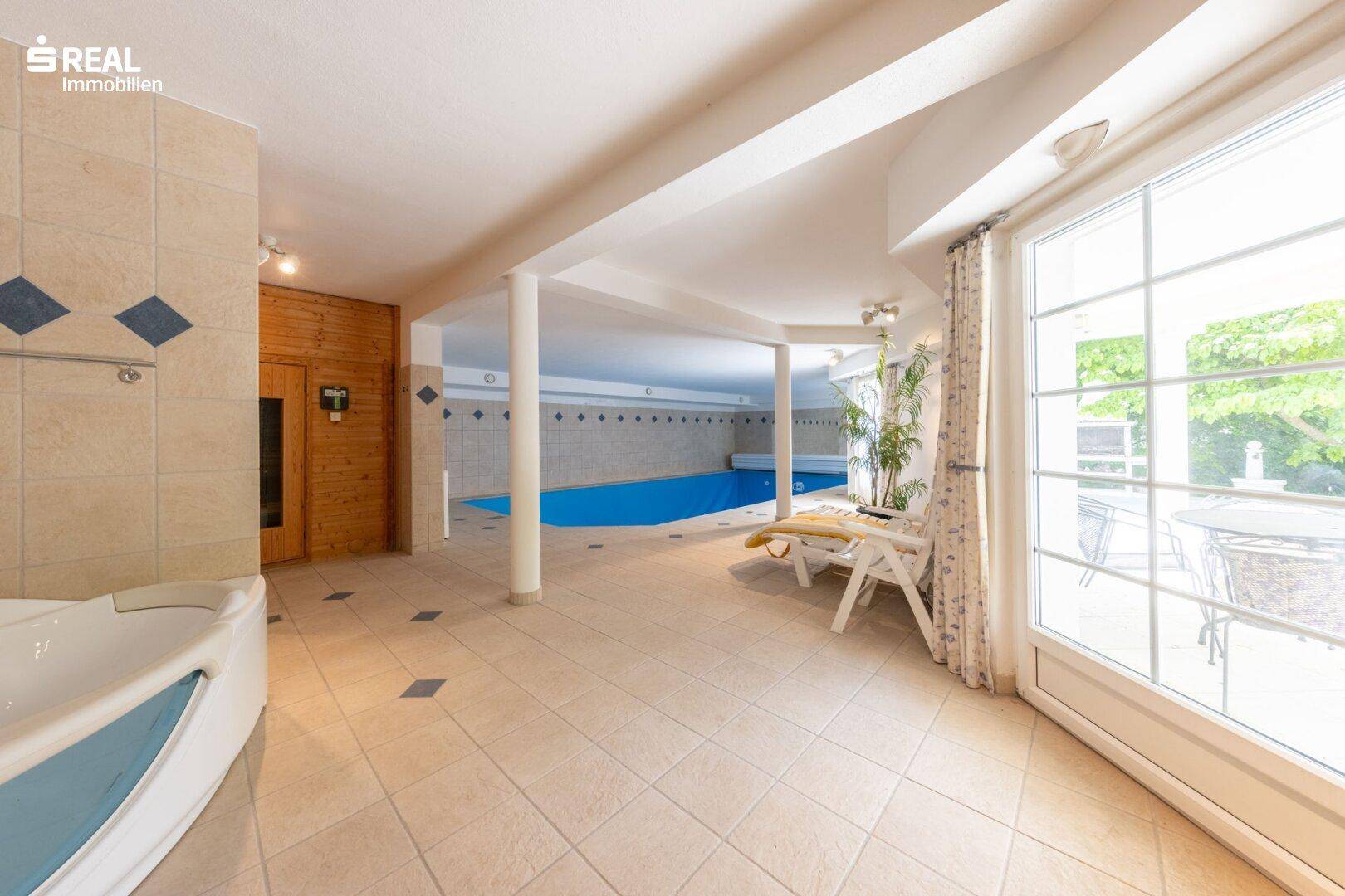 Großzügiger Wellnessbereich mit Innenpool, Whirlpool und Sauna, ideal zur Entspannung.