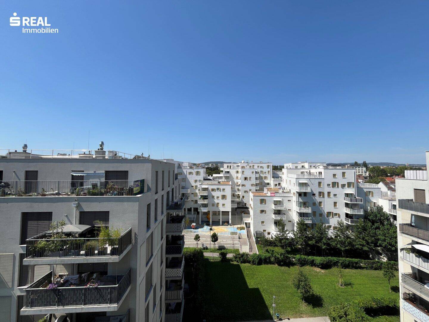 Panoramablick über die moderne Wohnanlage mit vielen Balkonen und Grünflächen.