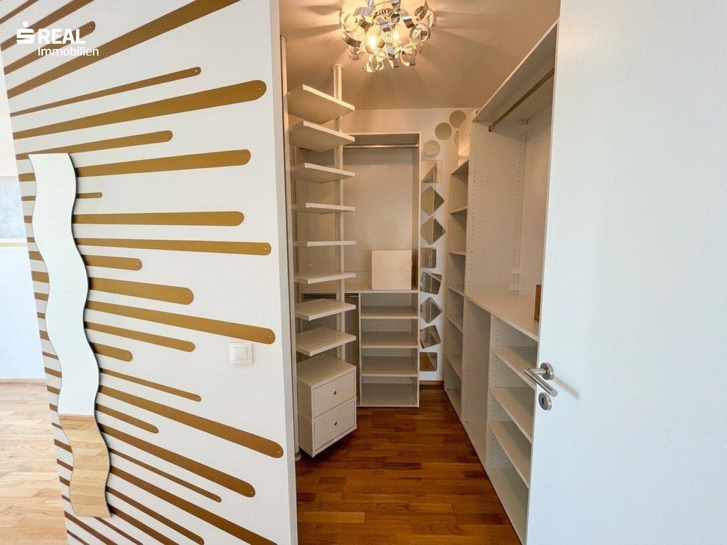 Praktischer begehbarer Kleiderschrank mit vielen Regalen und Stauraum.