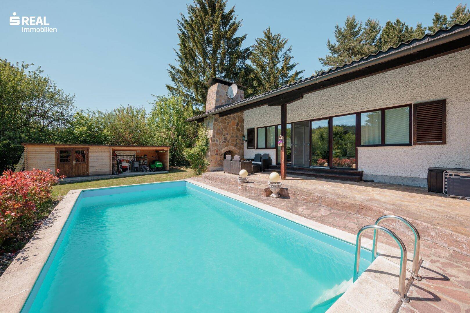 Blick auf das Haus mit einem erfrischenden Pool und einer gepflasterten Terrasse für entspannte Stunden.