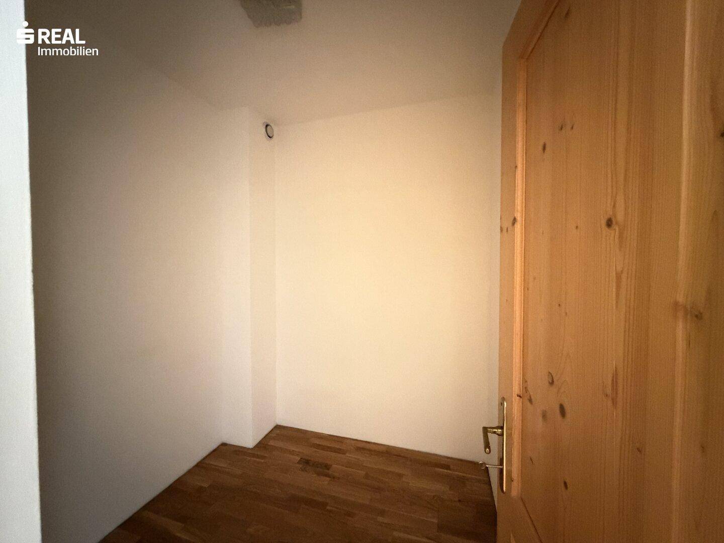 Kleiner, leerer Raum mit Parkettboden, ideal als Abstellraum oder begehbarer Kleiderschrank nutzbar.