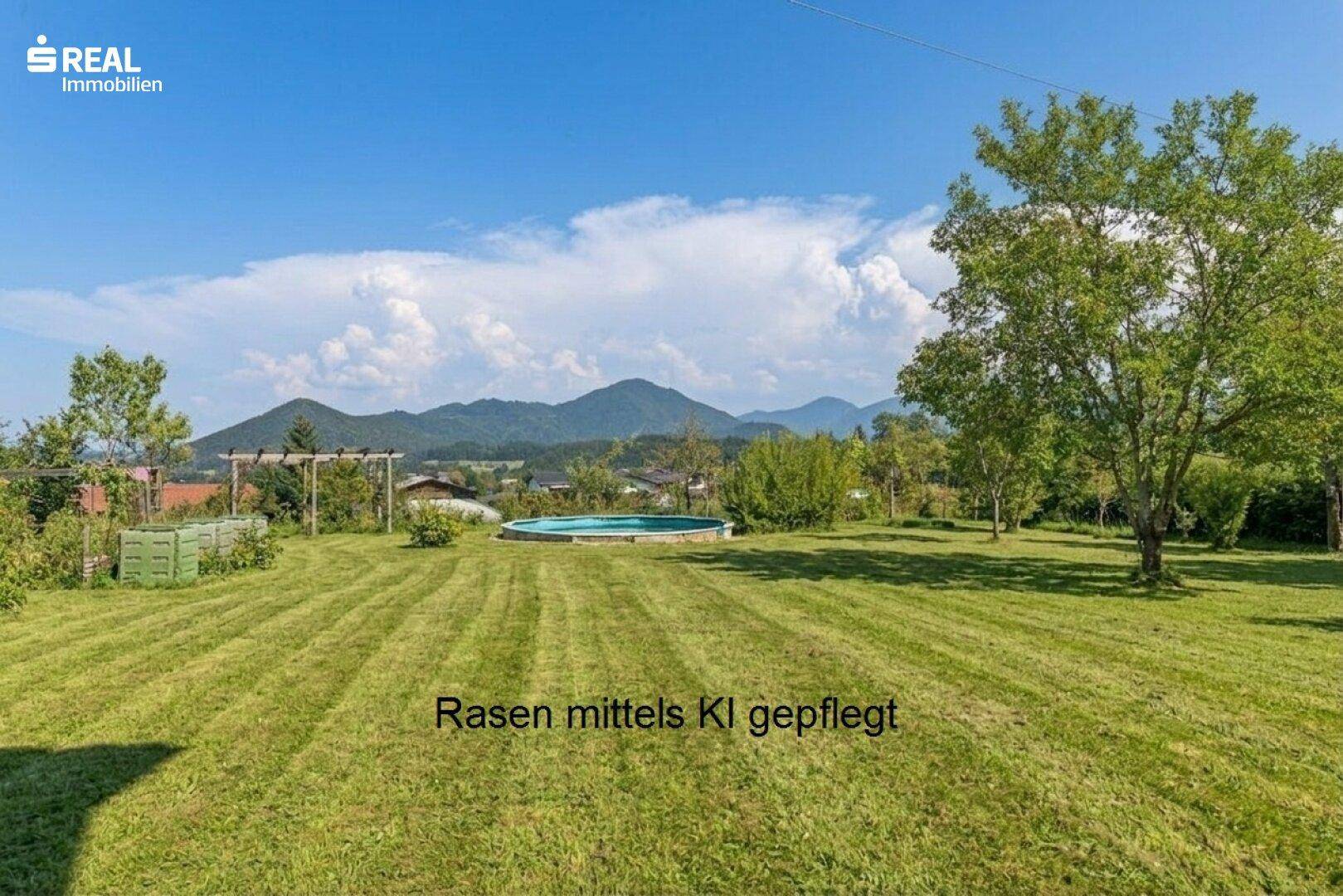Weitläufige, gepflegte Rasenfläche mit kleinem Pool und malerischem Bergblick im Hintergrund.