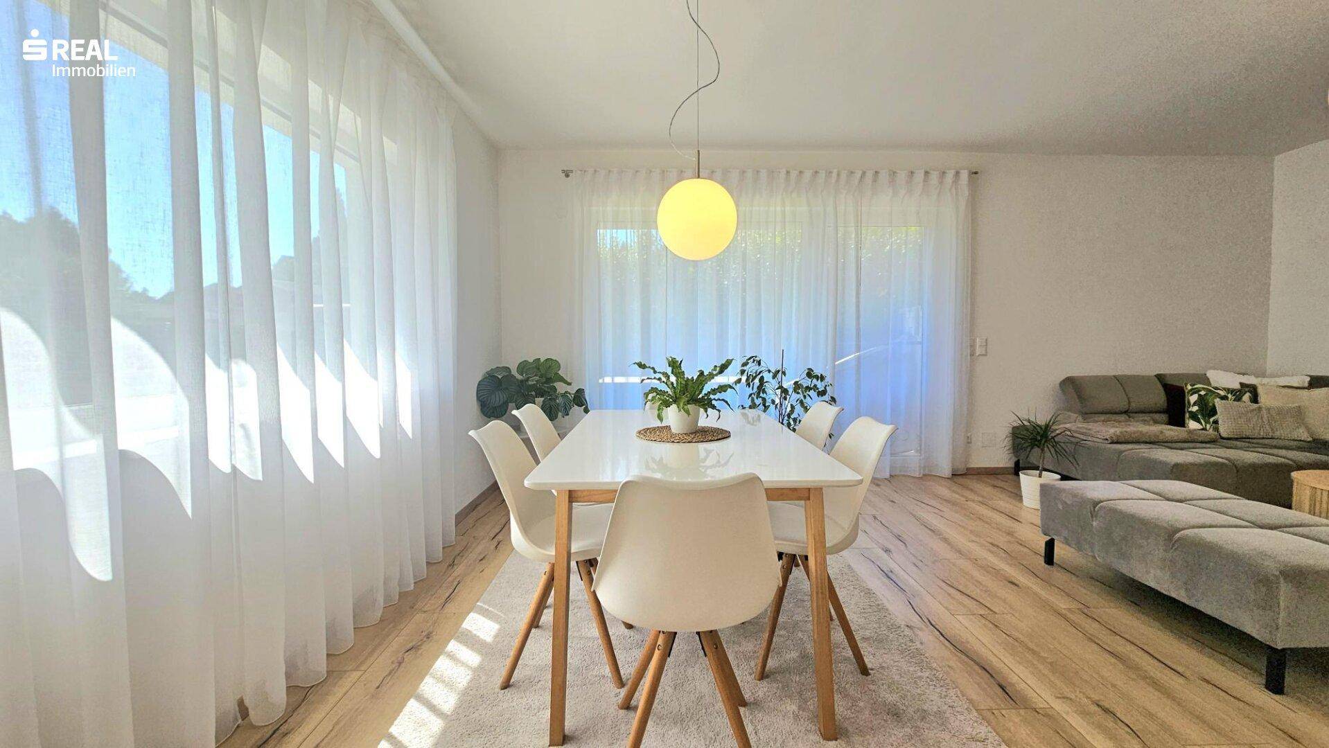 Lichtdurchfluteter Essbereich mit modernem Esstisch und Stühlen, direkt am Fenster gelegen.