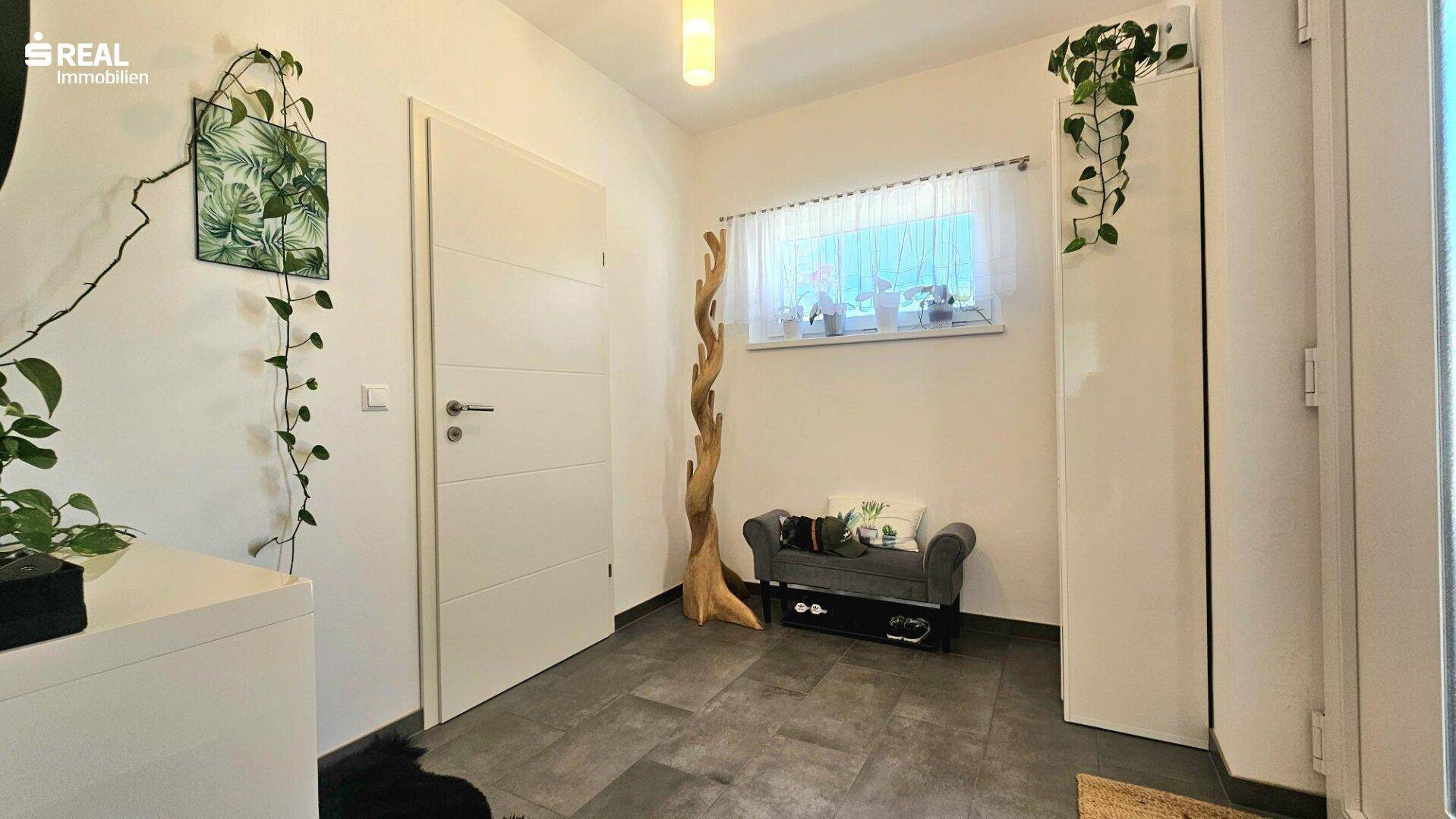 Freundlicher Flur mit Fenster, Sitzbank und praktischem Stauraum.