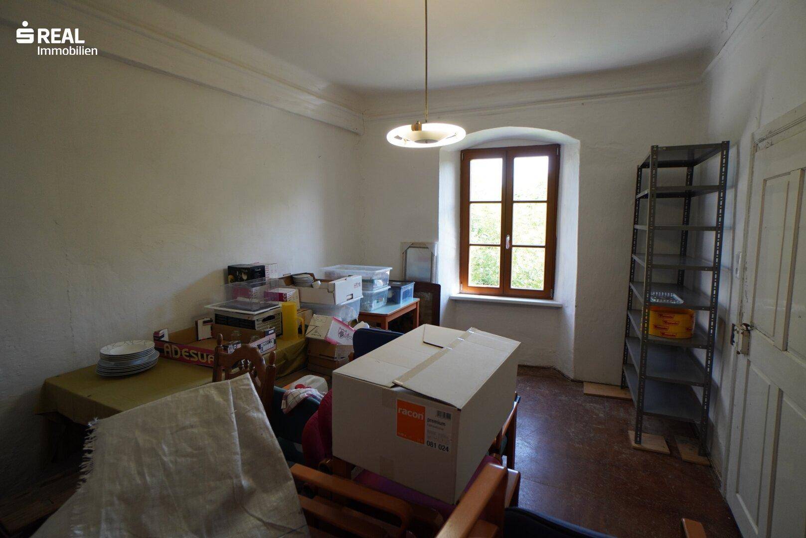 Abstellraum mit einem Fenster und verschiedenen gelagerten Gegenständen.