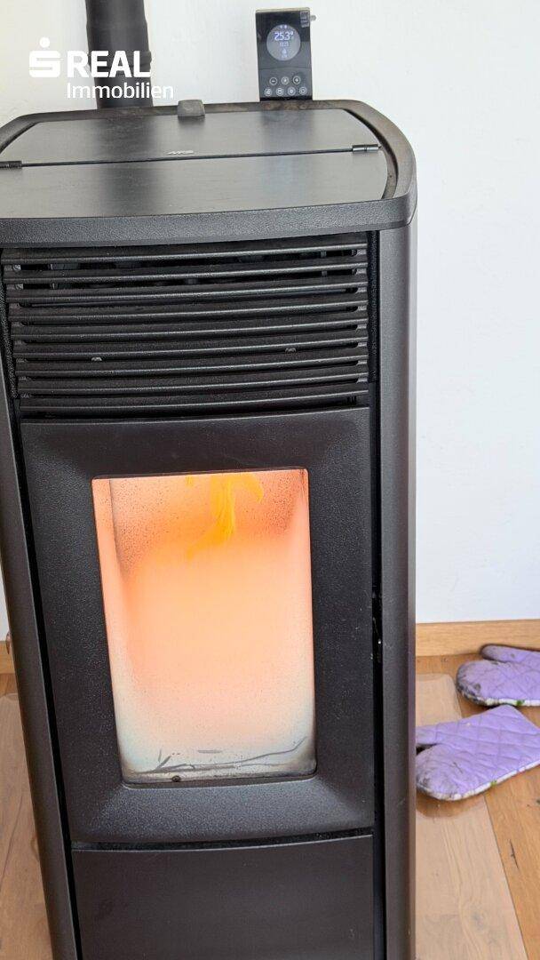 Moderner Pelletofen mit sichtbarer Flamme, der eine gemütliche Wärme spendet.