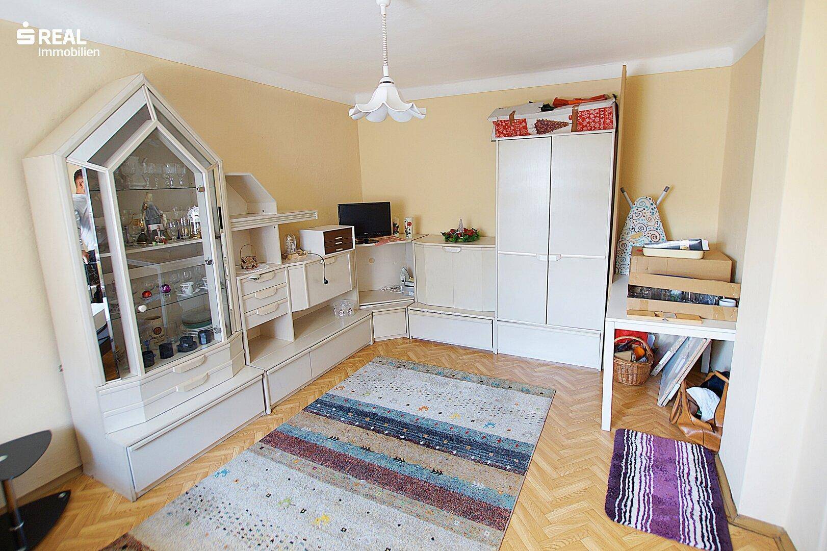 Schlafzimmer mit Schrankwand, Teppich und Stauraum unter den Dachschrägen.