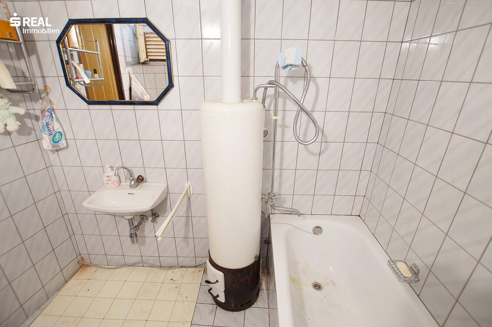 Badezimmer mit Badewanne, Waschbecken und Spiegel.