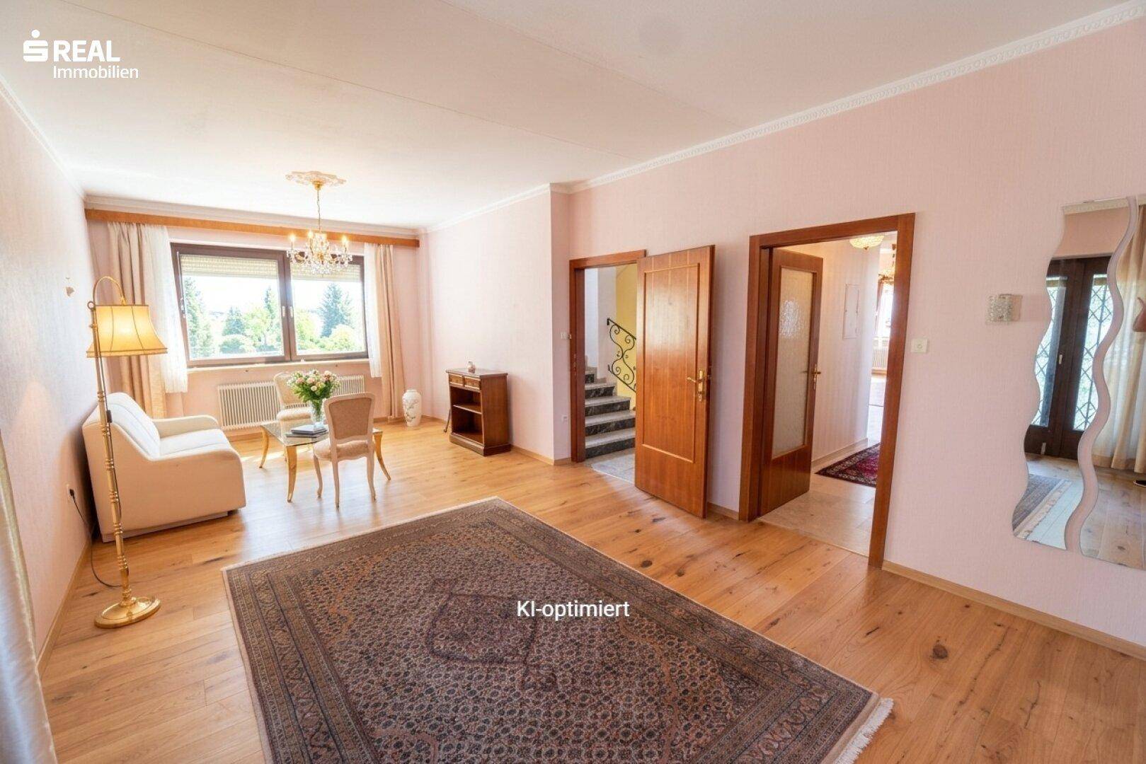 Gemütliches Wohnzimmer mit Holzboden, Teppich und Blick auf den Treppenaufgang.