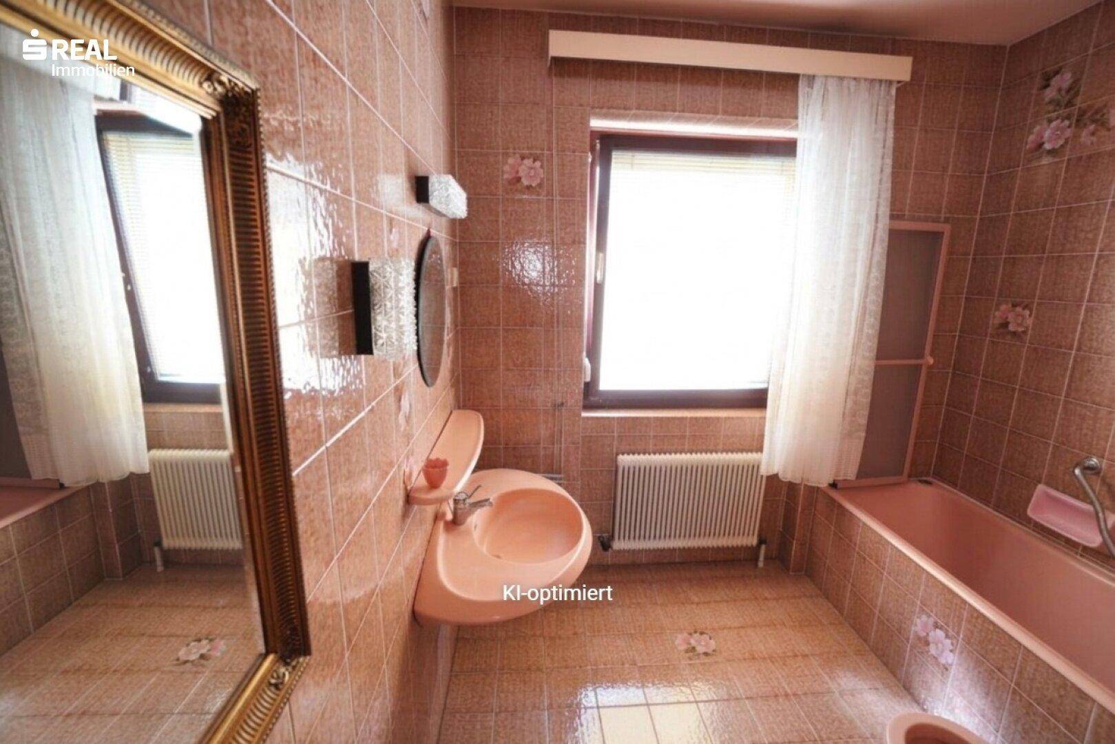 Badezimmer im 80er-Jahre-Stil mit rosa Fliesen, passendem Waschbecken und Badewanne.