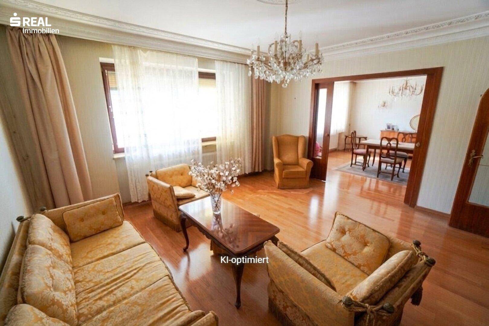 Klassisches Wohnzimmer mit eleganten Möbeln, Parkettboden und einem Durchgang zum Essbereich.