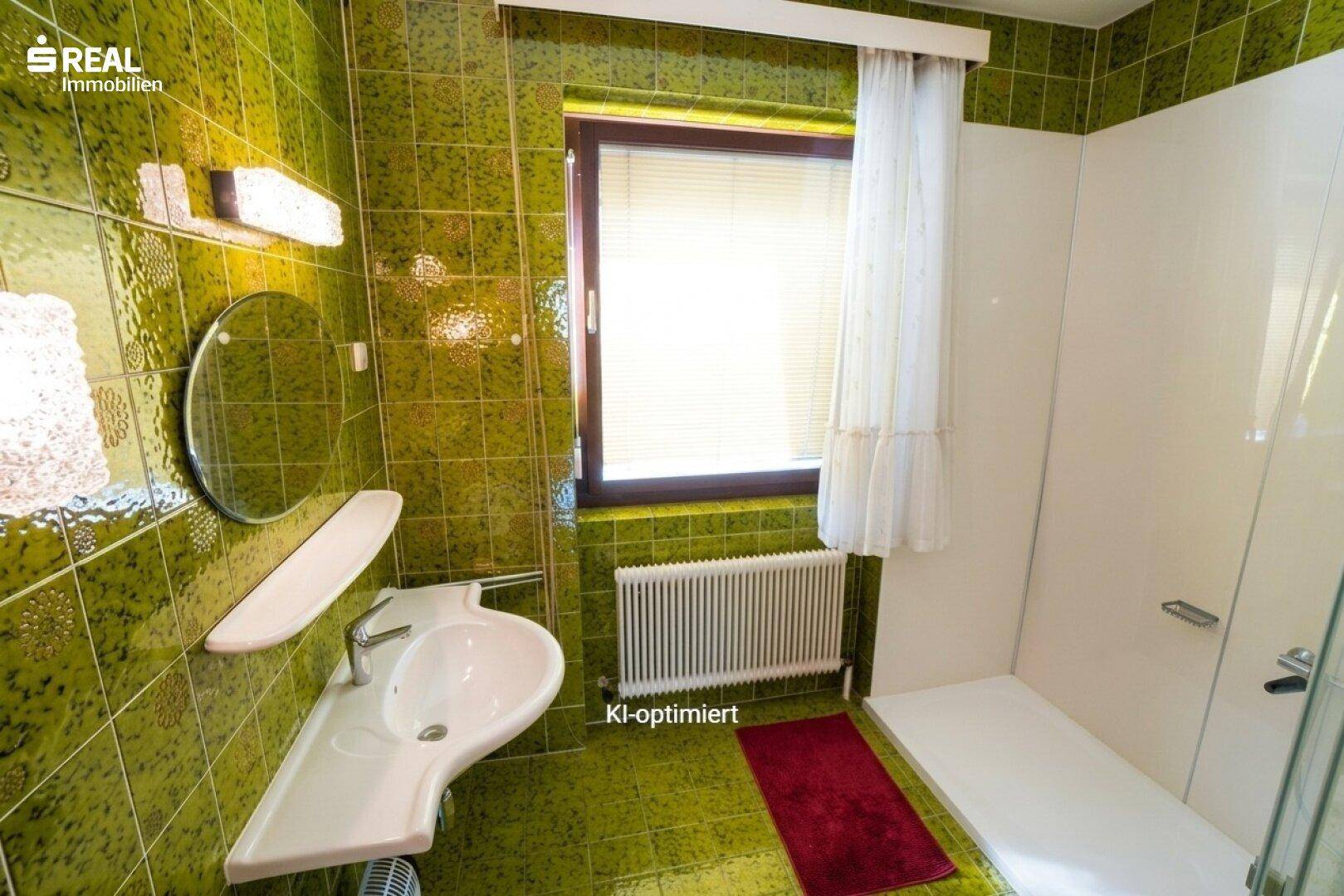 Badezimmer mit auffälligen grünen Fliesen, modernem Waschbecken und Duschbereich.