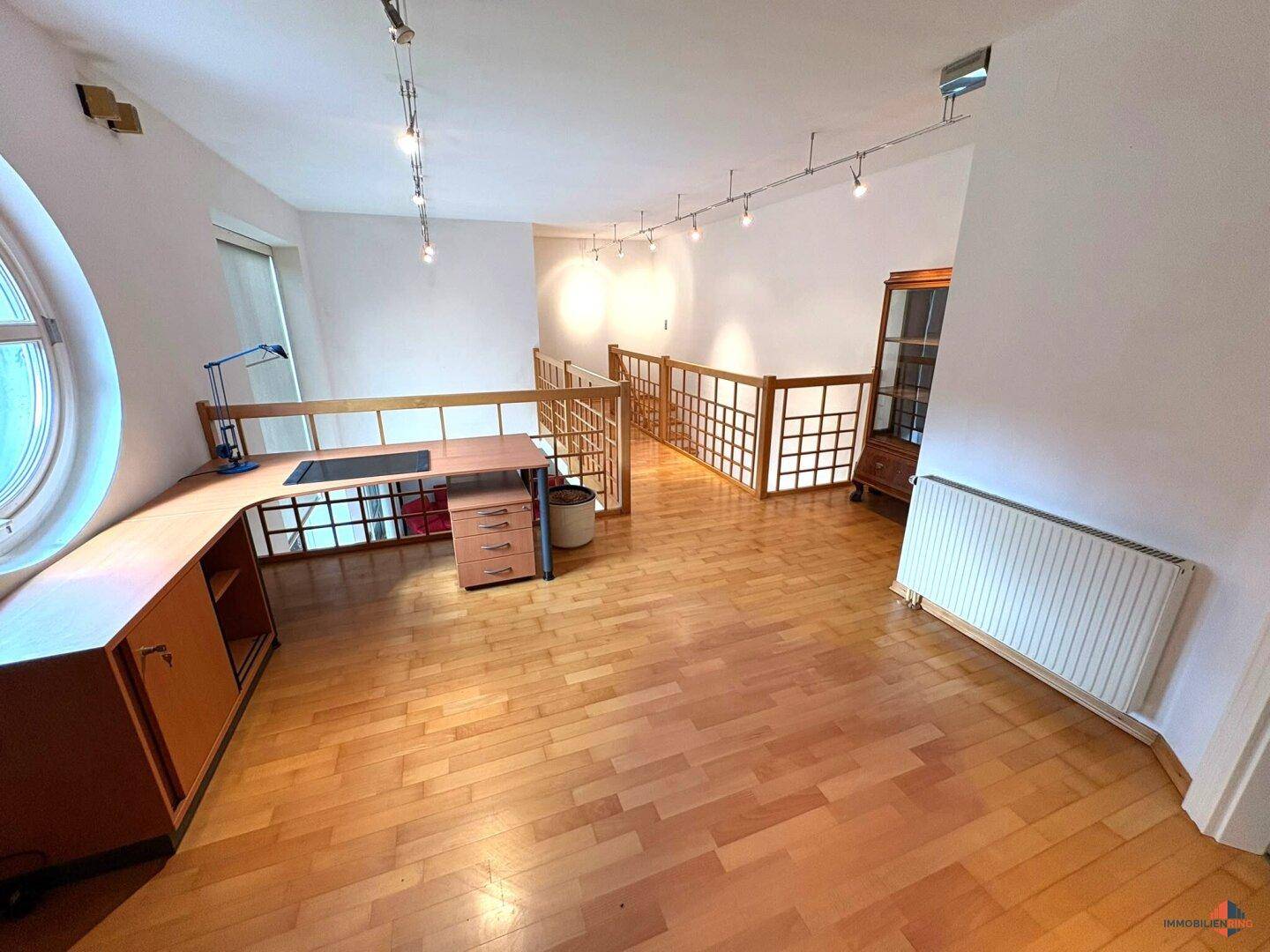 Heller Arbeitsbereich auf der Galerie mit Holzfußboden und viel Tageslicht.