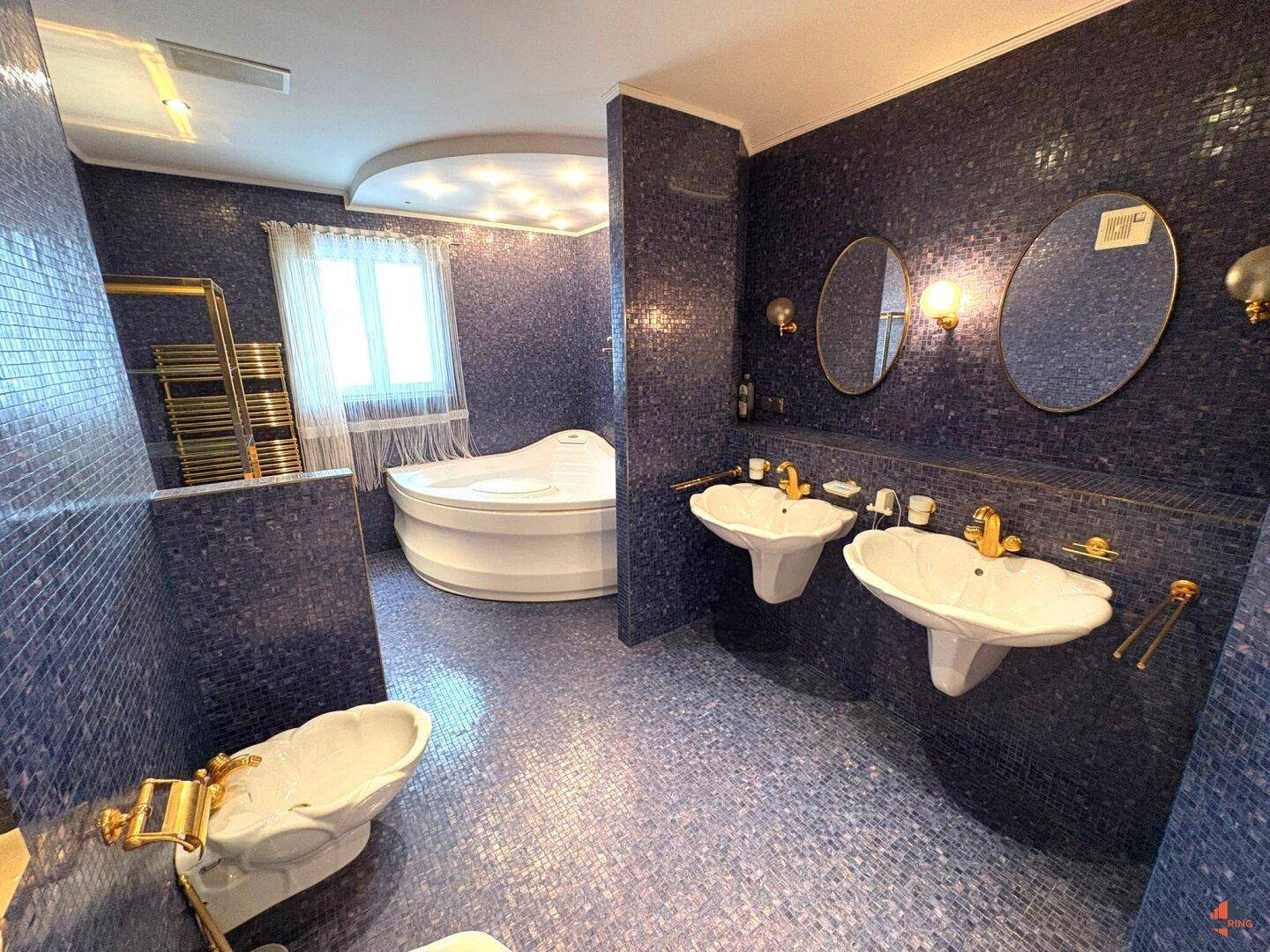 Exklusives Badezimmer mit blauen Mosaikfliesen, Doppelwaschbecken und Badewanne.