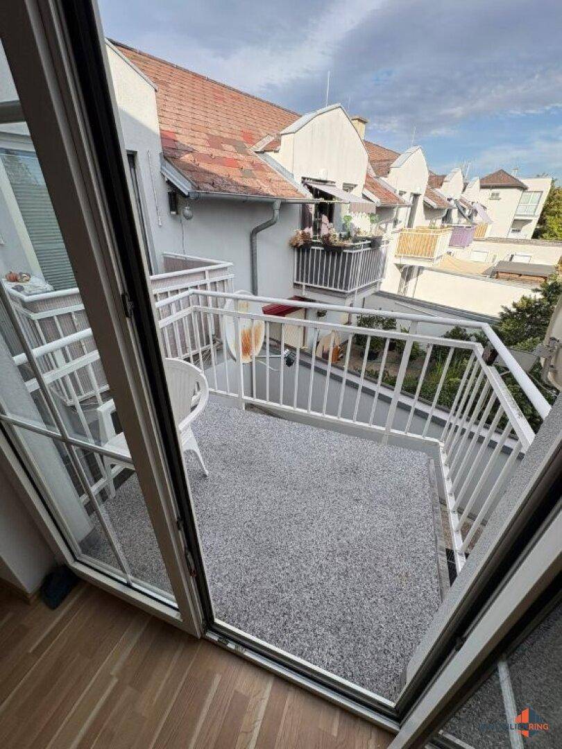Heller Balkon mit Zugang vom Innenraum und Blick auf die Nachbarschaft, perfekt für sonnige Tage.