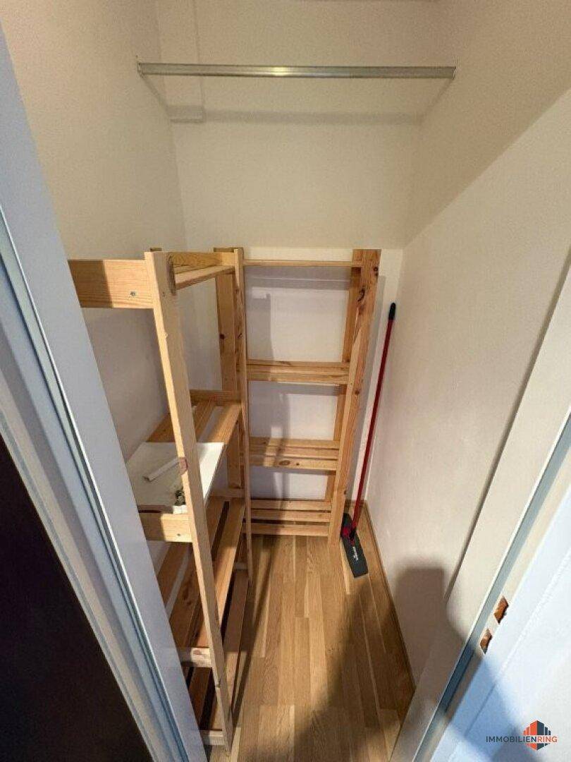 Praktischer Abstellraum mit Holzregalen für zusätzlichen Stauraum, gut organisiert.