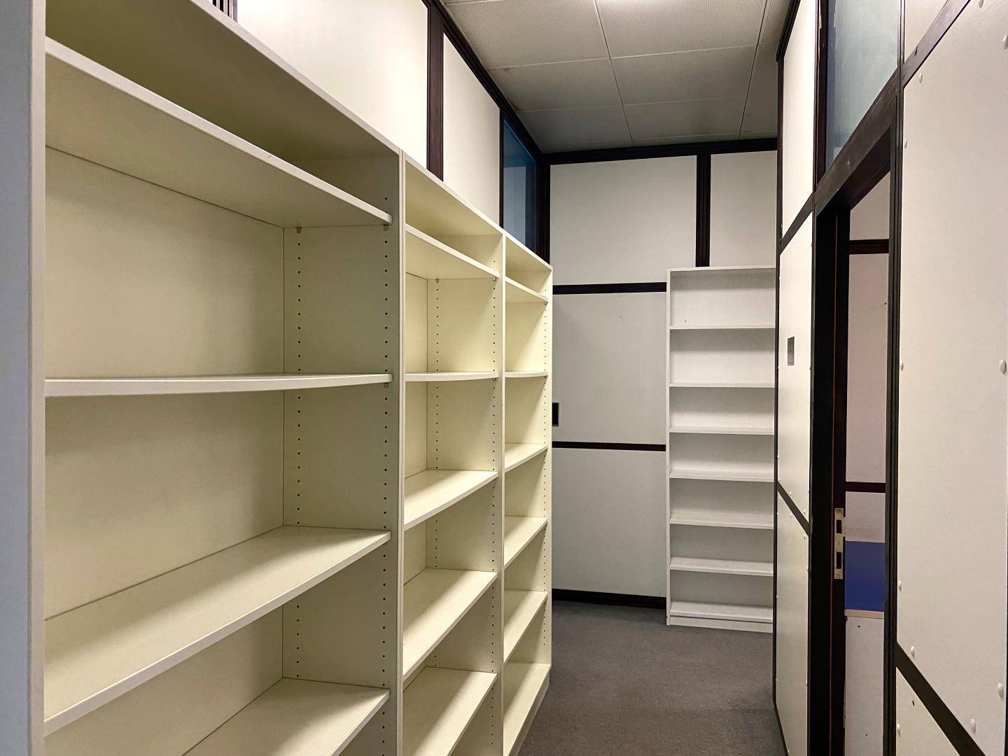 Lagerraum oder Archiv mit vielen leeren Regalen und modularen Trennwänden.